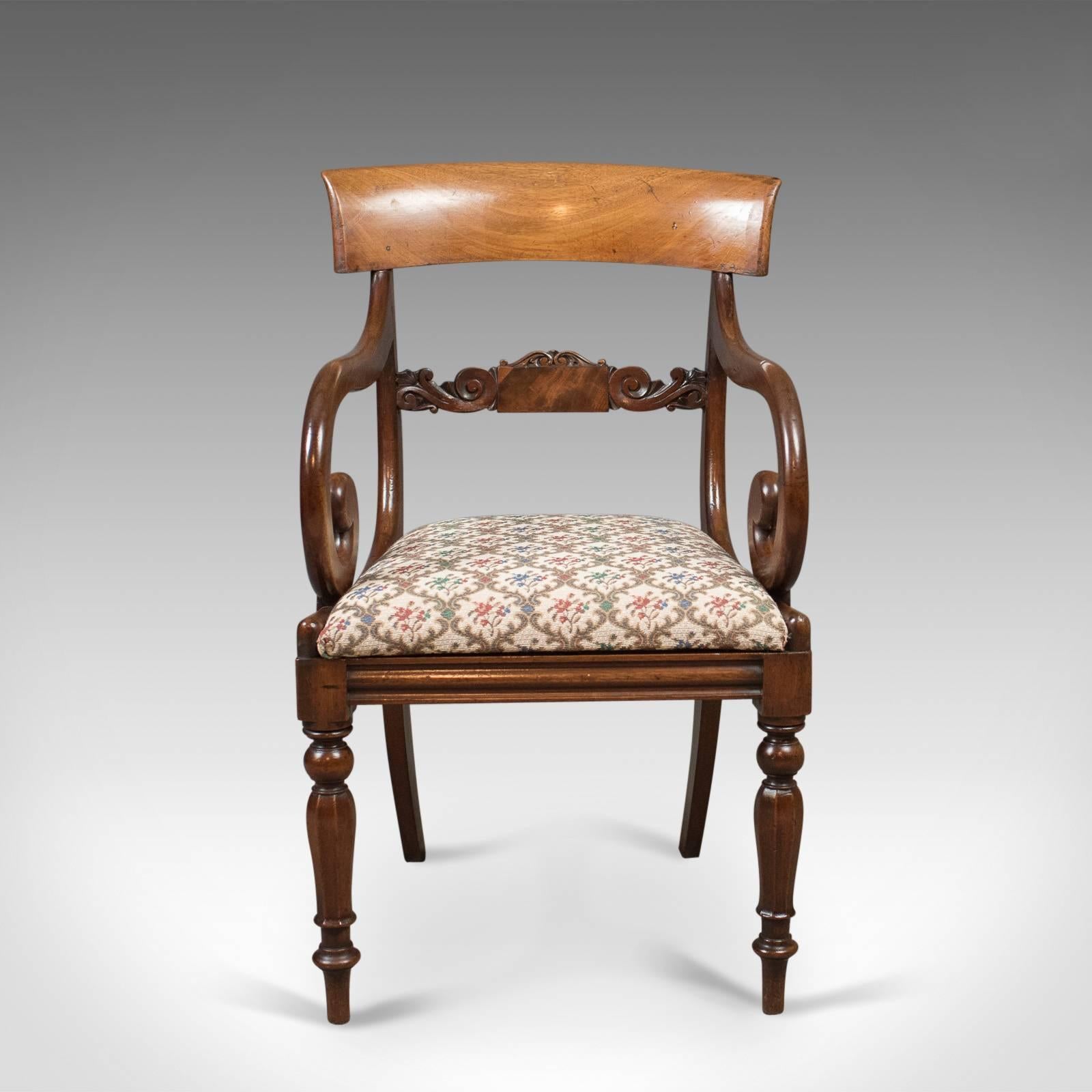 This is an antique scroll armchair in mahogany and dating to the Regency period c.1830.

Raised on delightfully turned, tapering, octagonal section legs
Pinched and swept tapering rear legs
Fluted front seat rail with side rails sweeping up into
