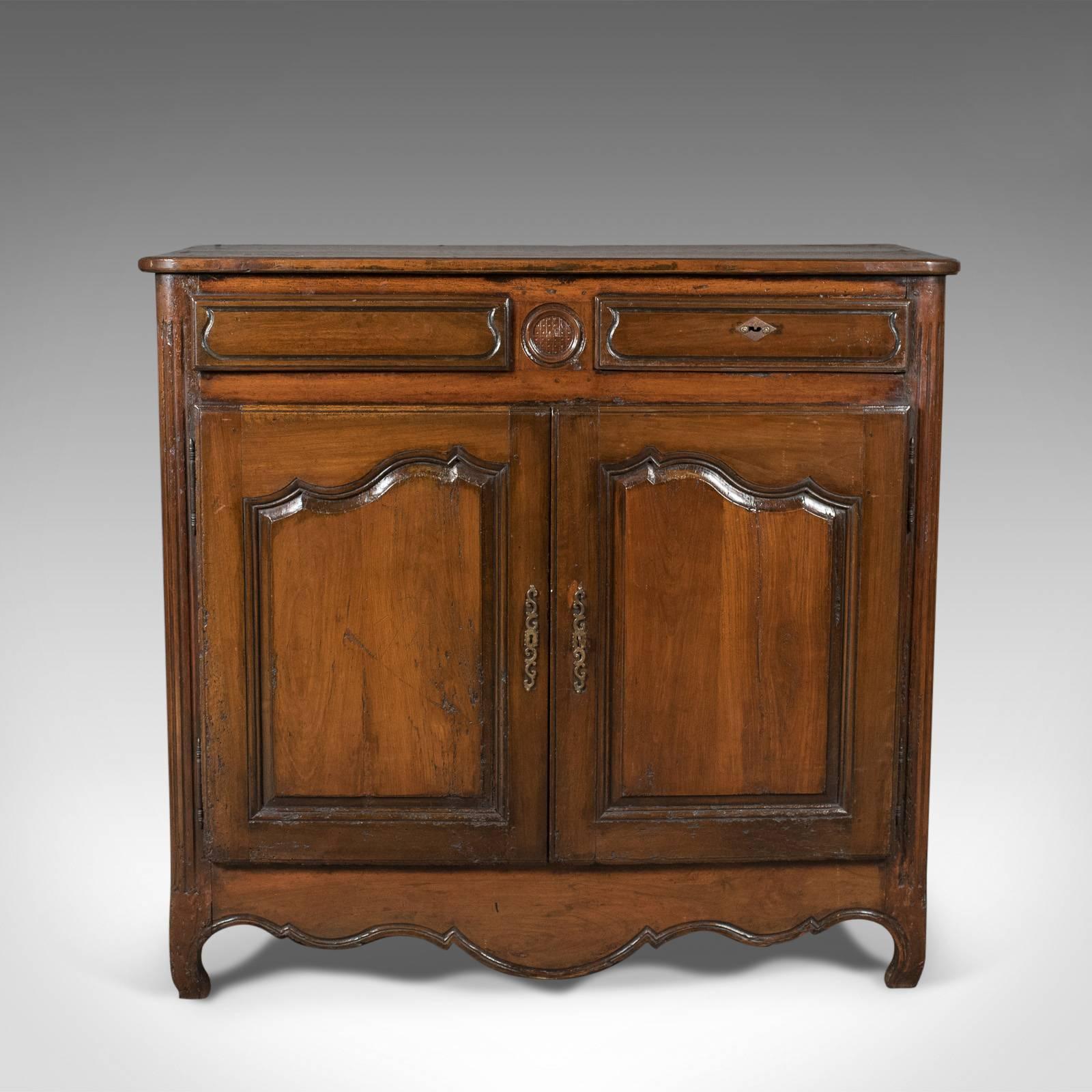 This is a French antique sideboard cabinet from the late 18th century, a walnut cupboard, circa 1780.

Attractive color to the walnut with an appealing aged patina
Two plank top with moulded edge detail
Rounded, fluted corners descending to
