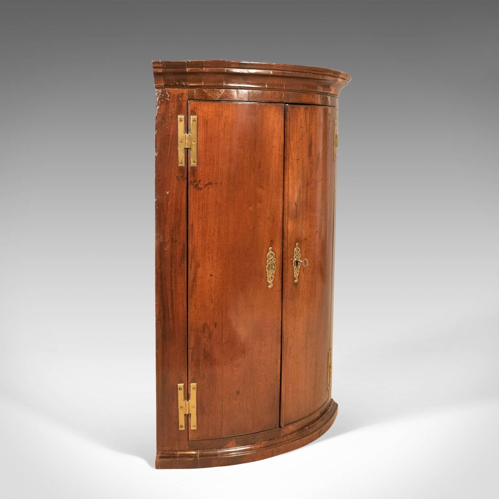 This is a fine example of a bow fronted antique corner cabinet, Georgian, circa 1725.

Superior example of an early Georgian corner cabinet
Mahogany front displaying good colour, grain interest and patina
Historic professionally re-carcassed in