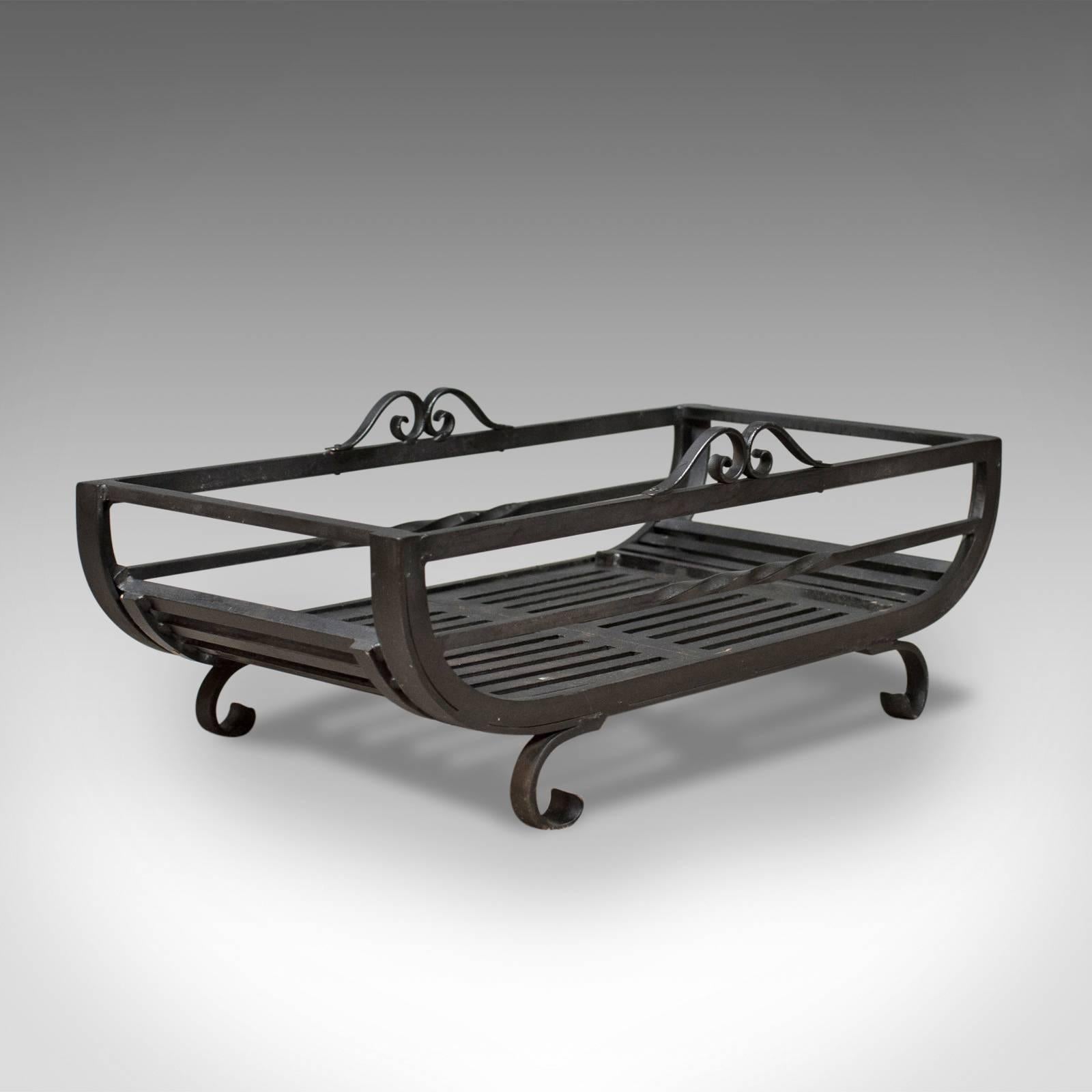 This is a large fire basket for the fireplace with an iron grate dating to the late 20th century.

A large fire grate presented in very good condition
A quality free-standing basket in attractive hand forged & cast iron
Useful low style standing