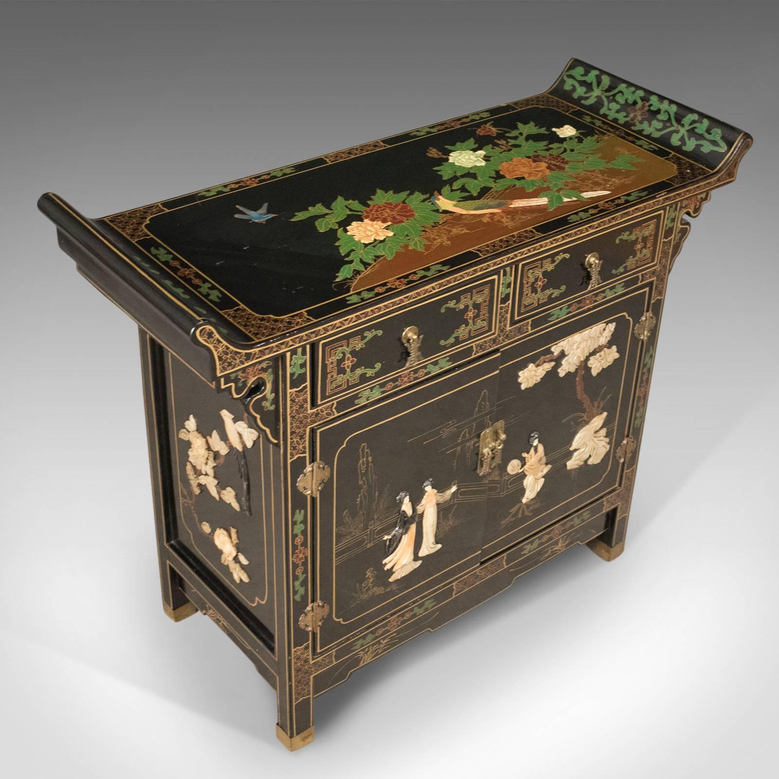 This is a fine quality, late 20th century, Japanese cabinet with soap stone decoration.

After traditional designs, a top quality cabinet with beautiful decoration
Bracketed, flared top with classic asymmetric design 
Two drawers over cupboard