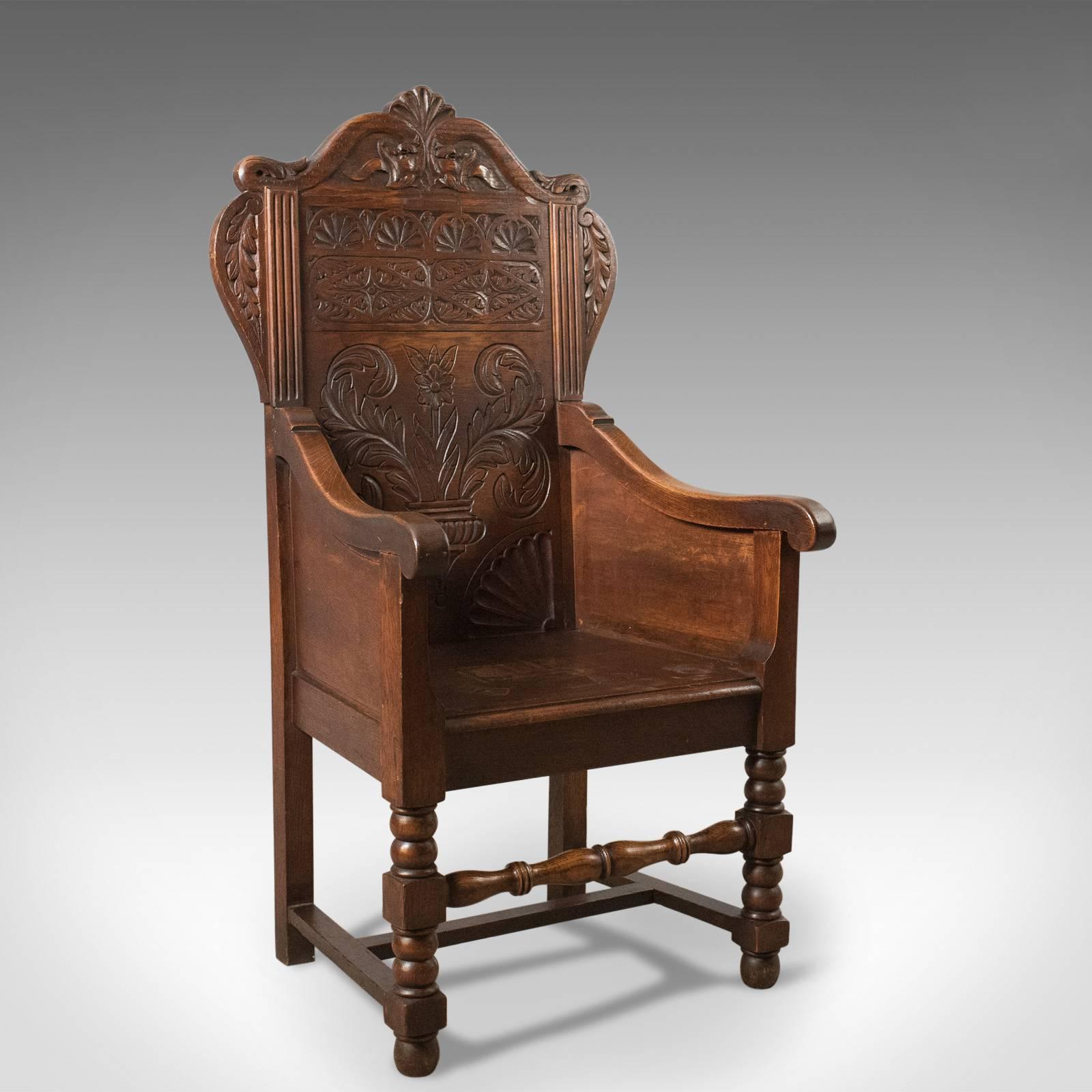 This is an antique pair of Baronial hall chairs. These English oak armchairs date to the late Victorian period, circa 1900.

A striking pair of carved oak chairs of substantial size and presence
Raised on box and ball front legs and square