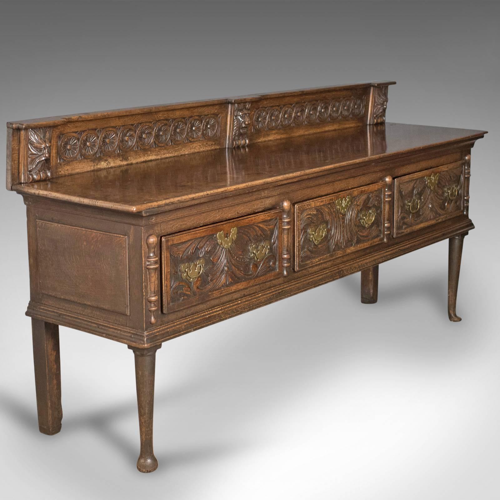 This is a Georgian oak dresser base from the 18th century. An English 'green man' sideboard dating to circa 1790.

Solidly constructed in oak with desirable color and patina
Displaying wisps of medullary rays in the lustrous wax polished