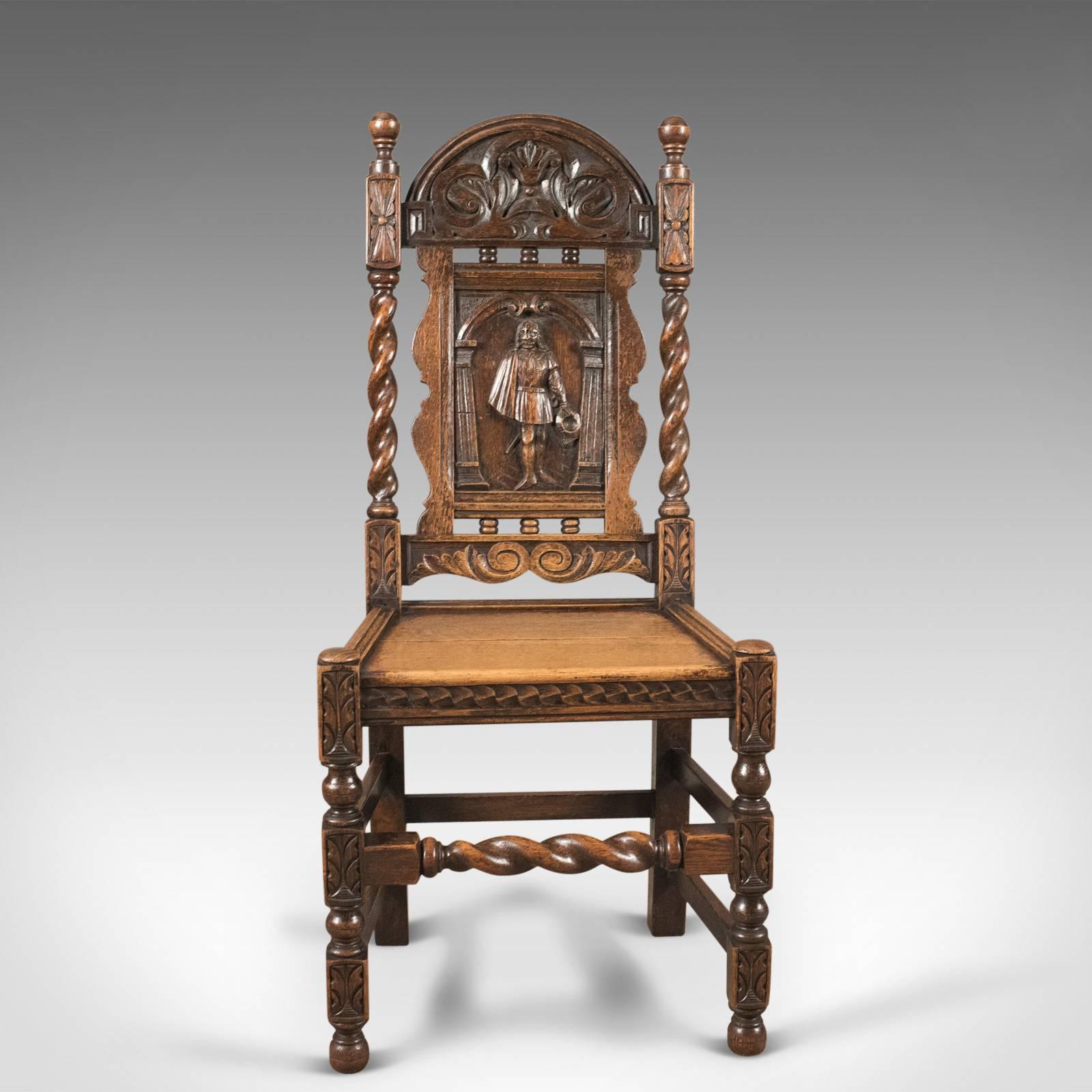 This is an antique Flemish hall chair in carved oak dating the turn of the century, circa 1900.

Good color and grain interest to the oak
Feature carved splat depicting a cavalier, hat doffed within a colonnade
Framed within a shaped border over