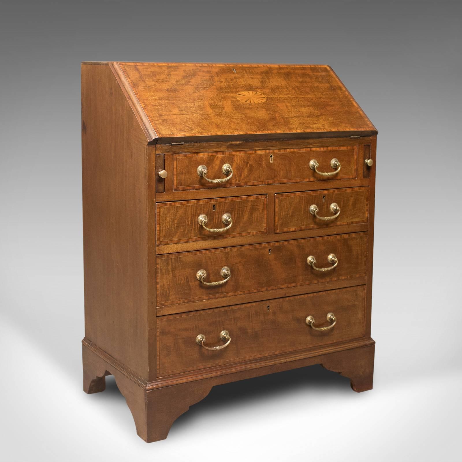 This is an Edwardian antique bureau in mahogany and oak. An English desk featuring a secret compartment, dating to circa 1910.

Quality craftsmanship in polished light mahogany and oak
Attractive honey tones highlighted with crossbanding and an