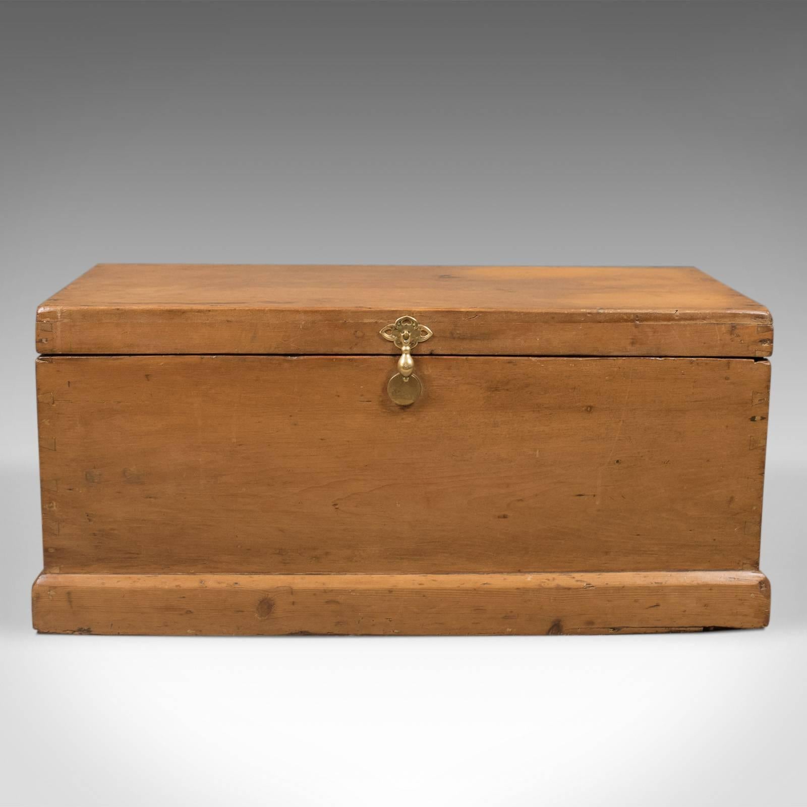 This is a mid Victorian antique pine trunk, an English carriage chest dating to circa 1860.

Attractive butterscotch hues to the waxed pine
A charming piece with desirable aged patina

Solid brass pendant handle over pierced brass quatrefoil