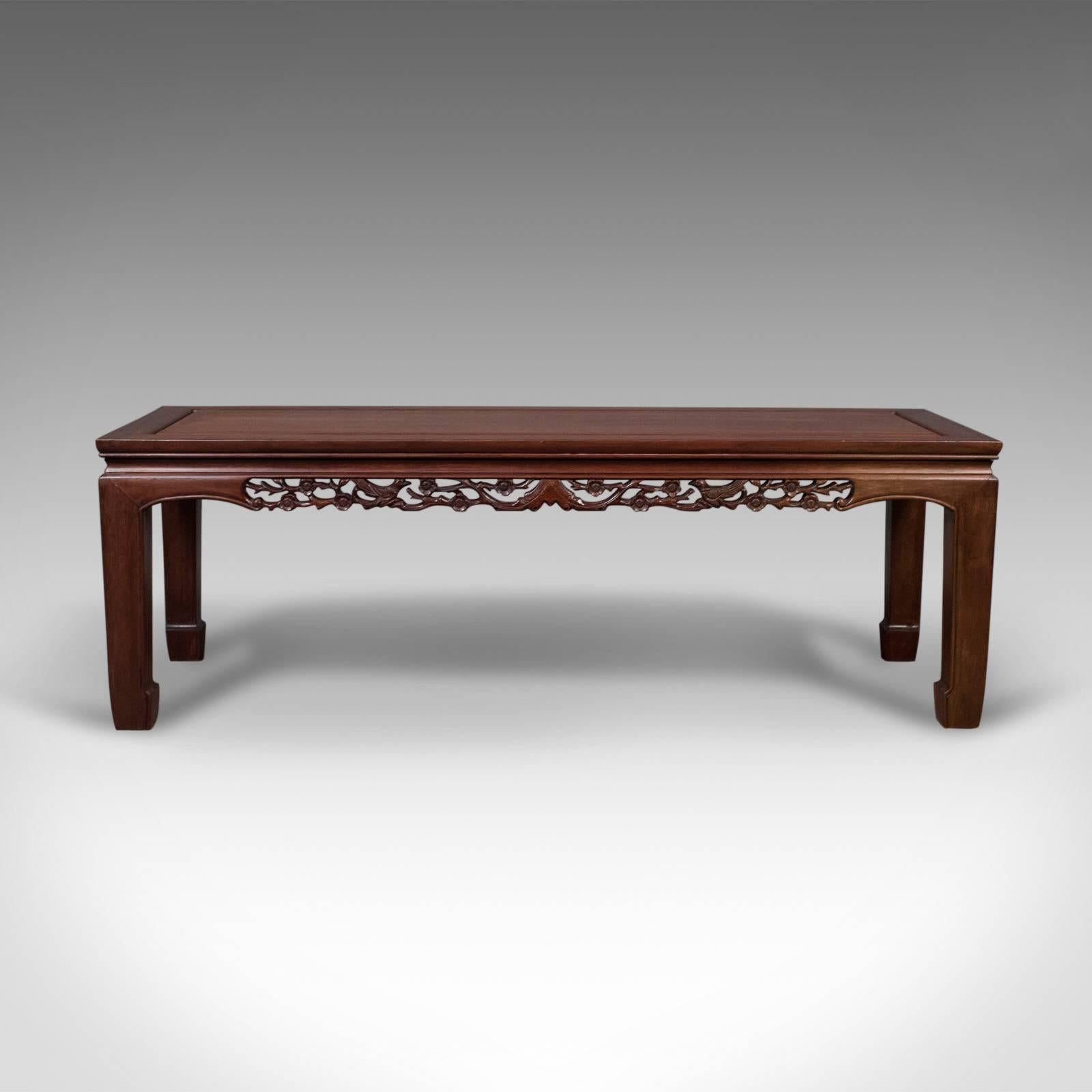 This is a midcentury Chinese rosewood coffee table in traditional form.

Rich, warm color in a satin waxed finish
The pierced carving a real feature of this otherwise typically understated piece
Well executed, depicting birds, flower heads and