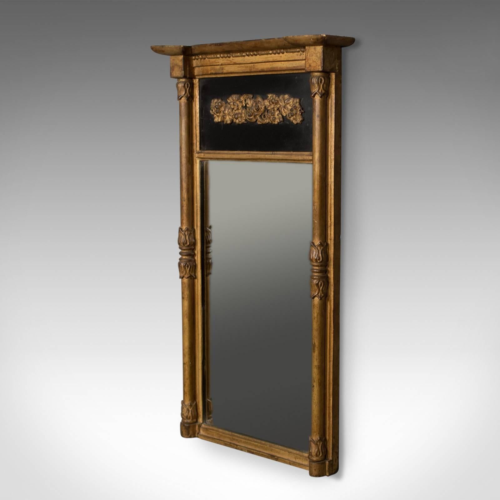 This is a Regency antique pier mirror in giltwood and gesso dating to the early 19th century, circa 1820.

Highly desirable natural color and patina to the giltwood frame
Superb proportions in classical form
Striking, contrasting, ebonized