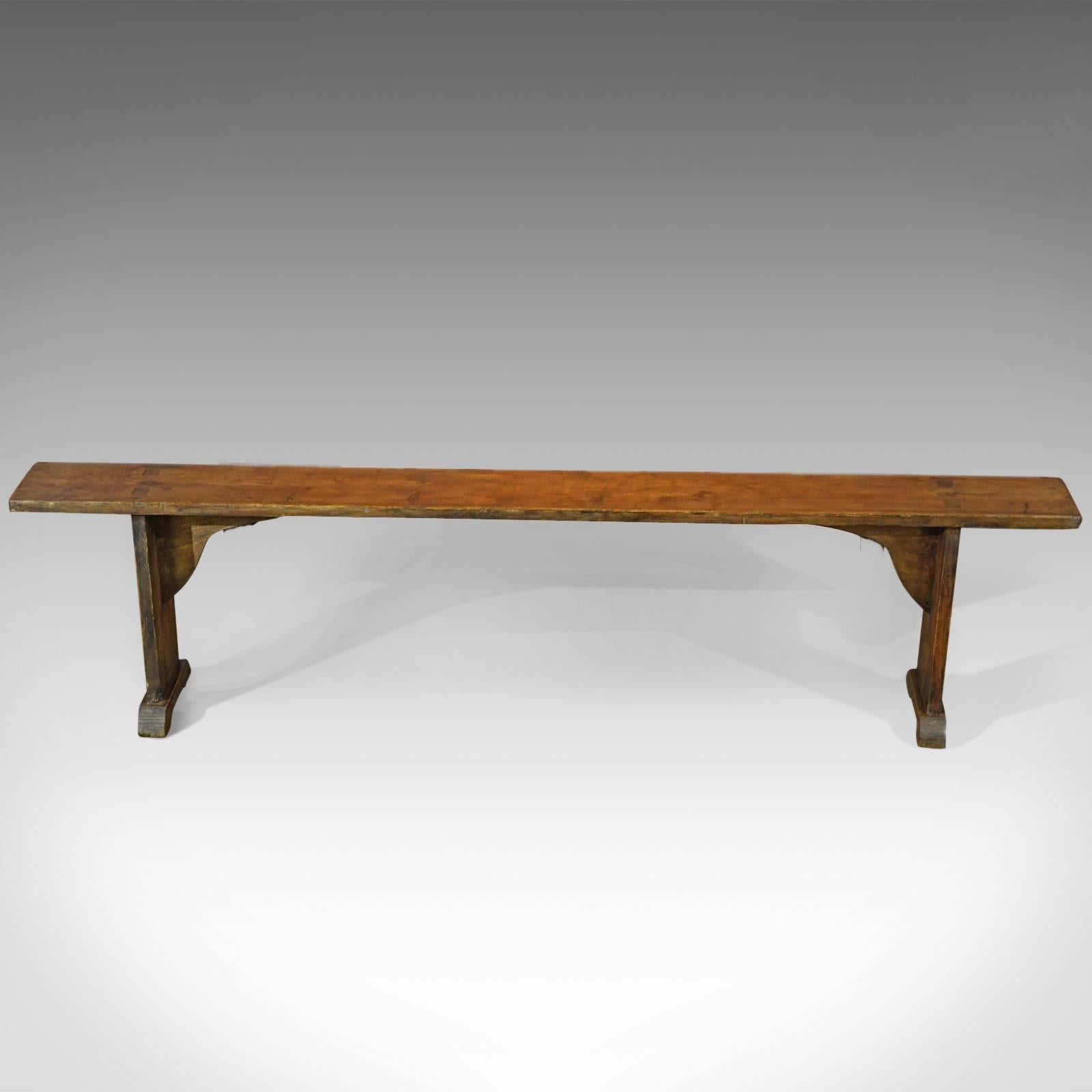 This is an antique bench dating to the turn of the century, circa 1900.

Raised on block section feet, this rustic pair of benches offer stable and generous seating and a nice alternative to dining chairs in a country kitchen.

Traditionally