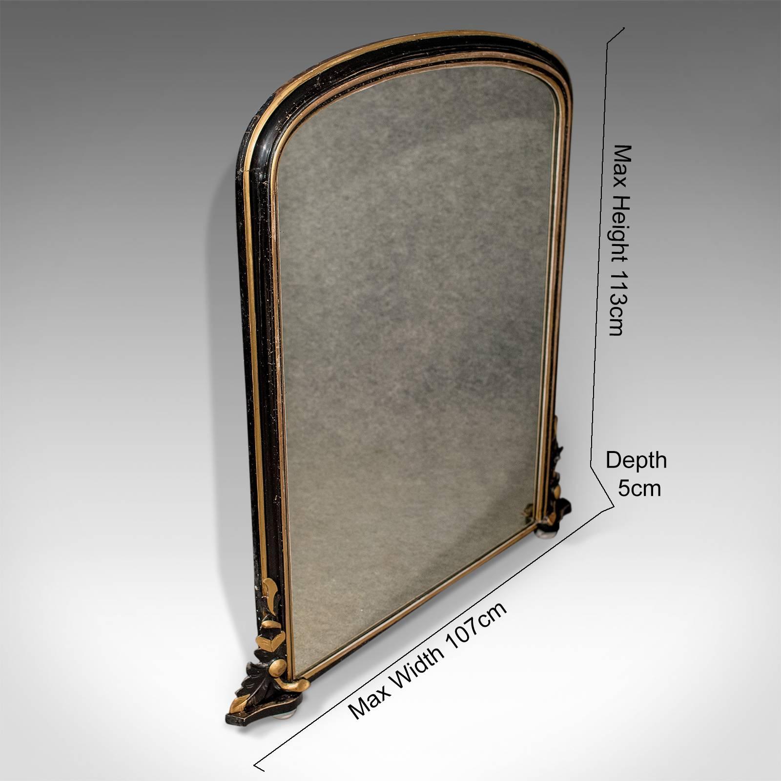 This is a Regency antique overmantel mirror in an ebonized giltwood frame dating to the early 19th century, circa 1820.

Highly desirable ebonized color and patina to the giltwood frame
Superb proportions in classical form
Quality hand-carved