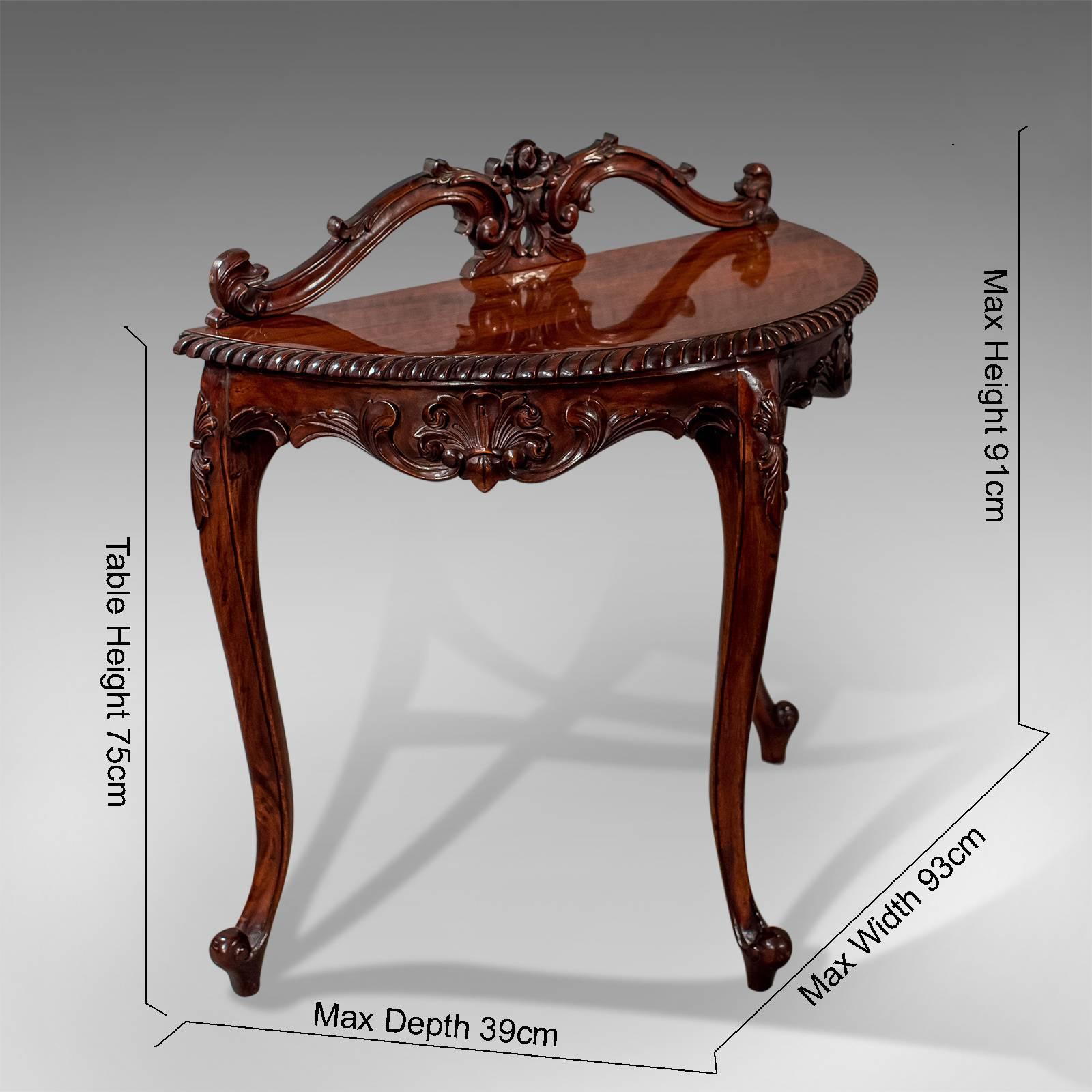This is an ornate demilune console table dating to the late 20th century in the Regency form.

Displaying beautifully as a feature table
Attractive mahogany with lustrous sheen
Classic colour and a desirable grain

Demi-lune form with