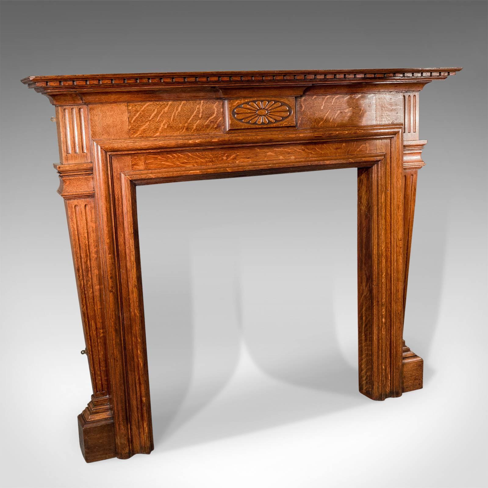 This is a large antique fireplace, an Edwardian mantelpiece fire surround in oak. English circa 1910.

English oak with fine colour throughout
Timber displaying desirable medullary rays 
Angled uprights flank to provide a pleasing architectural