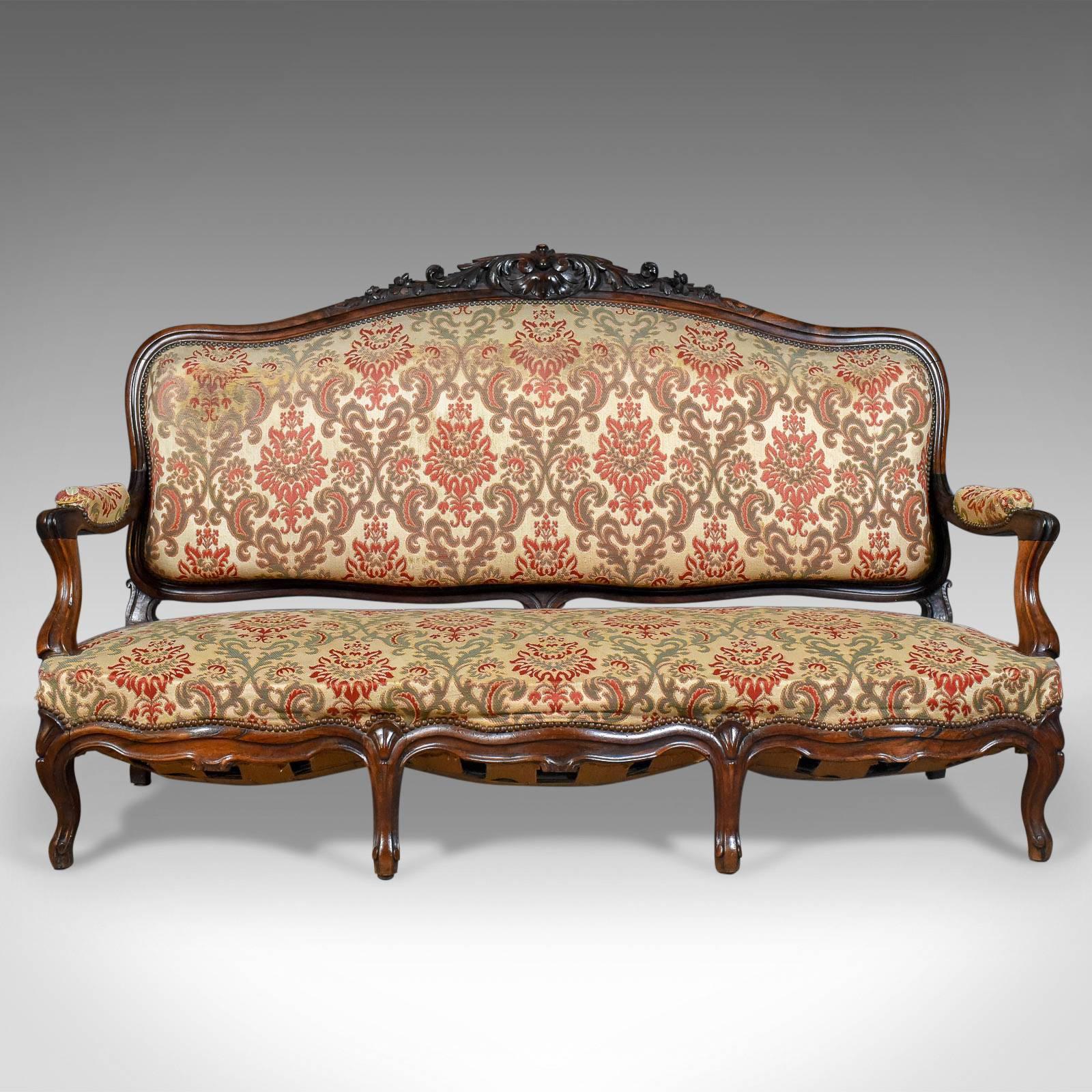 This is a Victorian antique settee on a rosewood frame, an English 19th century sofa dating to circa 1850.

A sumptuous piece of Victorian elegance
Dark rosewood frame with good color and desirable aged patina
Broad, comfortable seat with