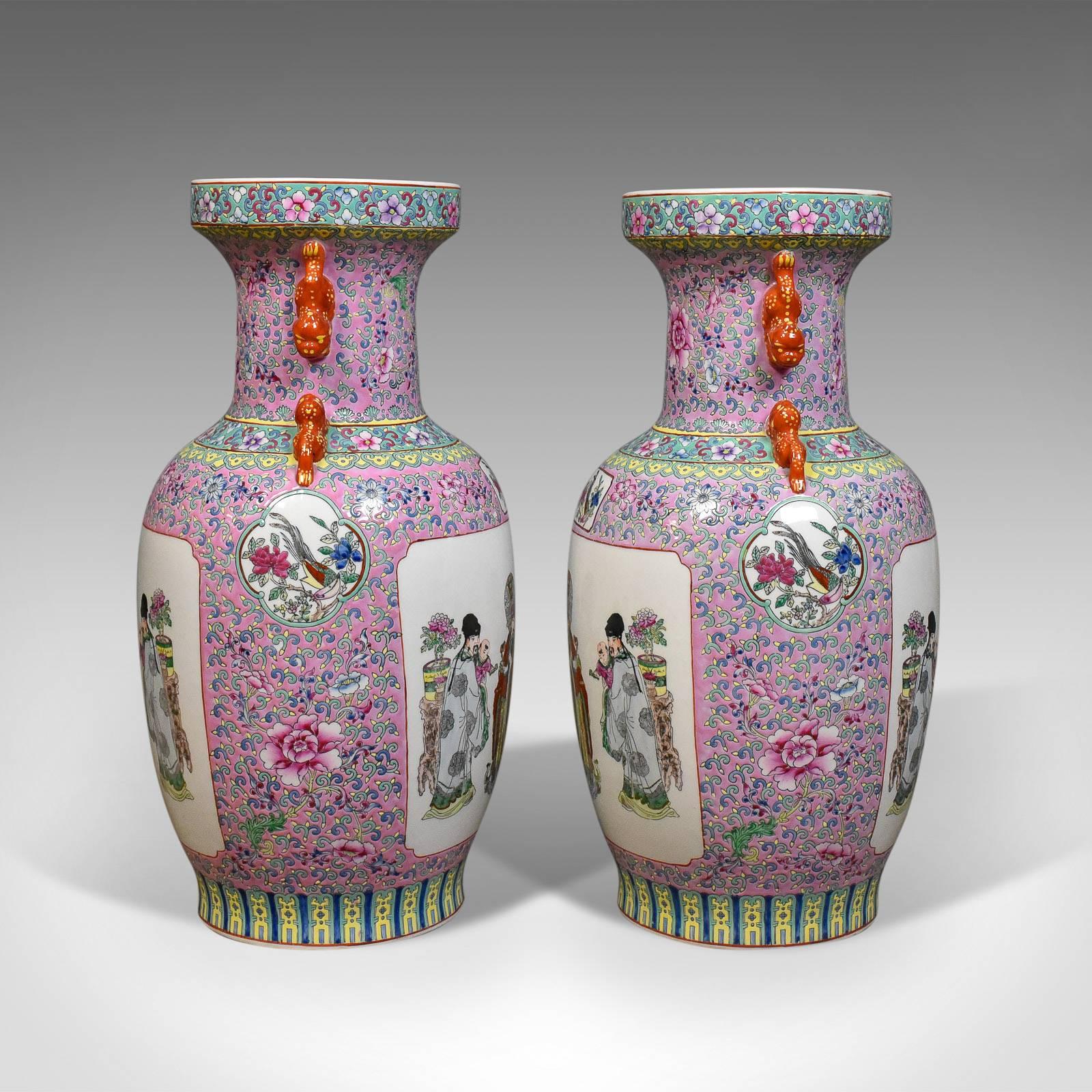 This is a midcentury pair of Chinese baluster vases, hand-painted ceramic urns. 

Imposing quality pair of ceramic vases 
Profusely decorated in blushes and reds
Free-from any damage or marks

Intense floral design to the neck and framing the