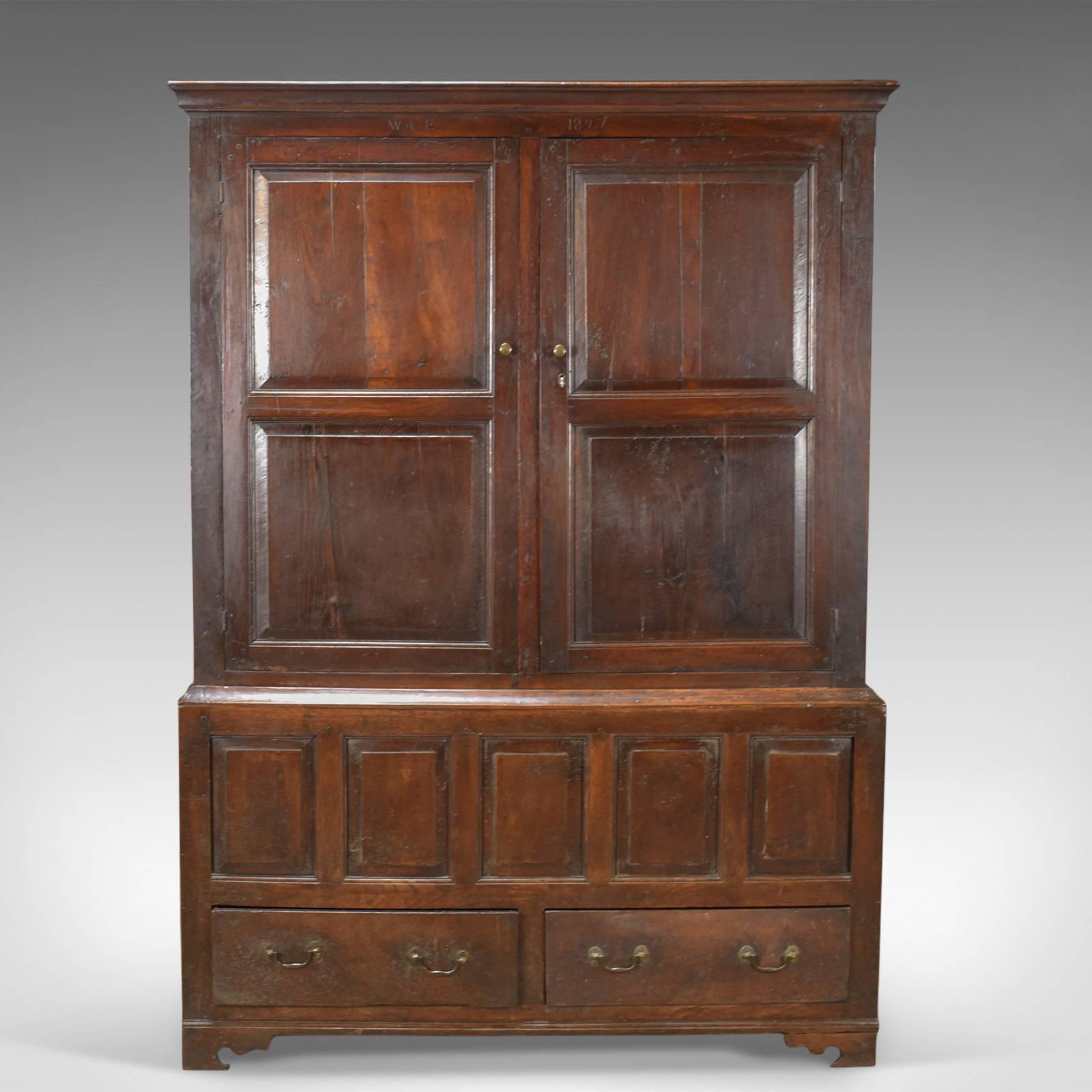 This is a late Georgian antique press cupboard, an English oak housekeeper's cabinet dating to circa 1780.

Attractive dark tones and desirable aged patina to the English oak
Appealing panelled construction standing upon spurred bracket