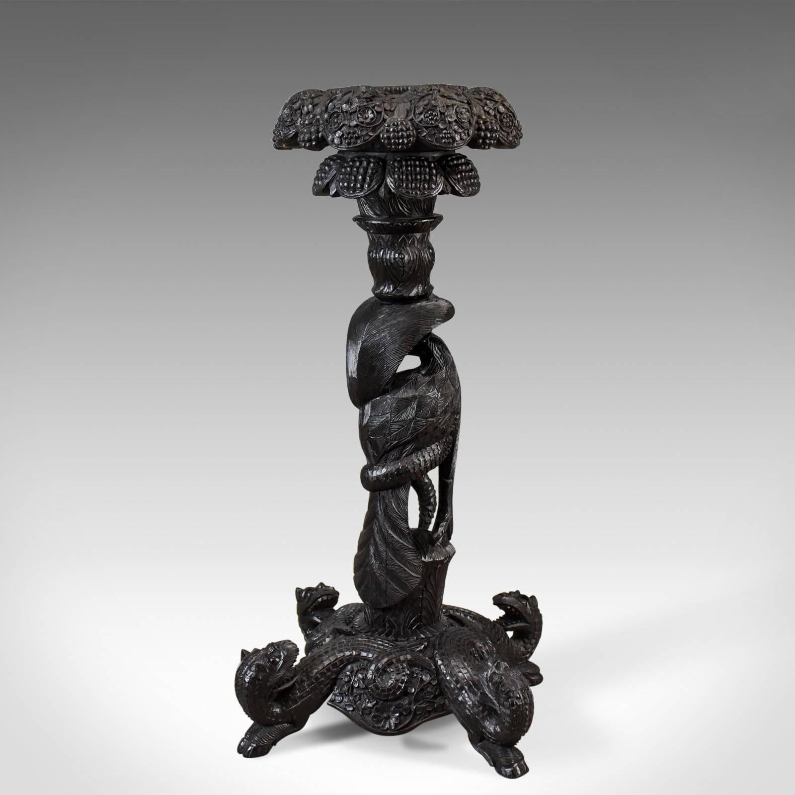 This is an antique jardiniere plant stand, a carved Asian torchere dating to the late 19th century, circa 1880.

A profusely carved stand very well executed
Teak with an appropriate ebonised finish
Generous, deep dished bowl receptacle