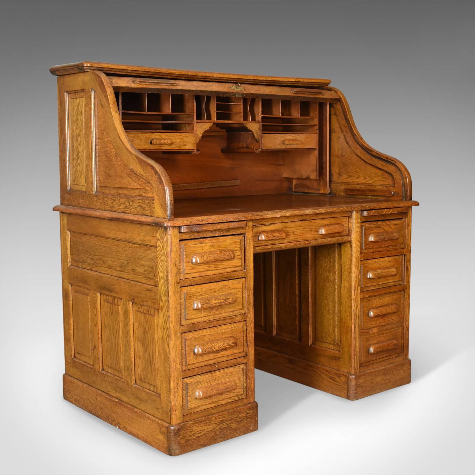 This is an antique roll top desk in English oak, late Victorian with locking tambour front dating to circa 1900.

A fine example with a show back ideal for centre room placement
English oak displaying good consistent colour with a desirable aged