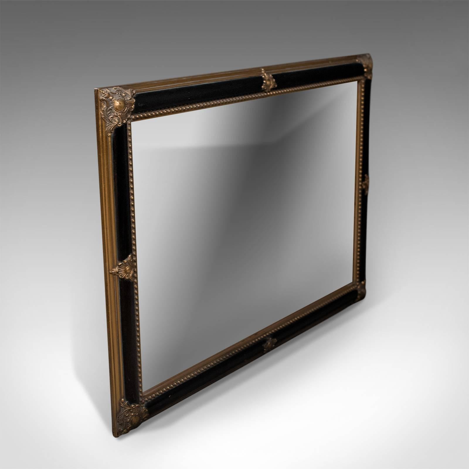 This is a Regency revival wall mirror. A quality item of decorative furniture made in the late 20th century.

Attractive ebonized finish to the giltwood frame
A refined piece made in the Regency taste
Mid-sized in good proportion and