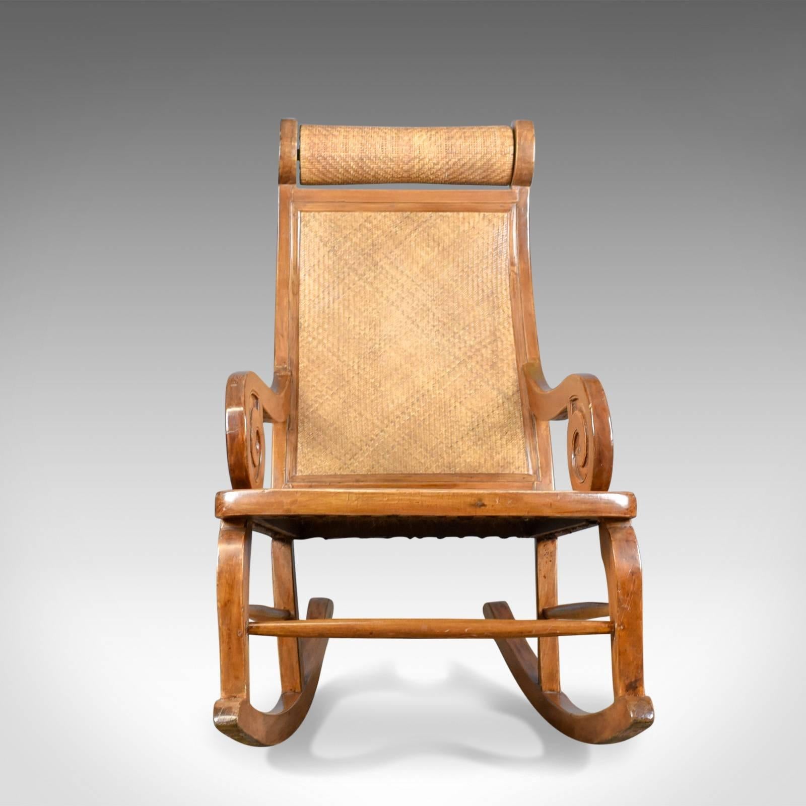 This is a midcentury vintage rocking chair, a hardwood and rattan recliner, circa 1970.

Comfortable high back rocking chair
Hardwood frame in very good order throughout
Displaying attractive caramel tones in a wax polished finish

Deep,
