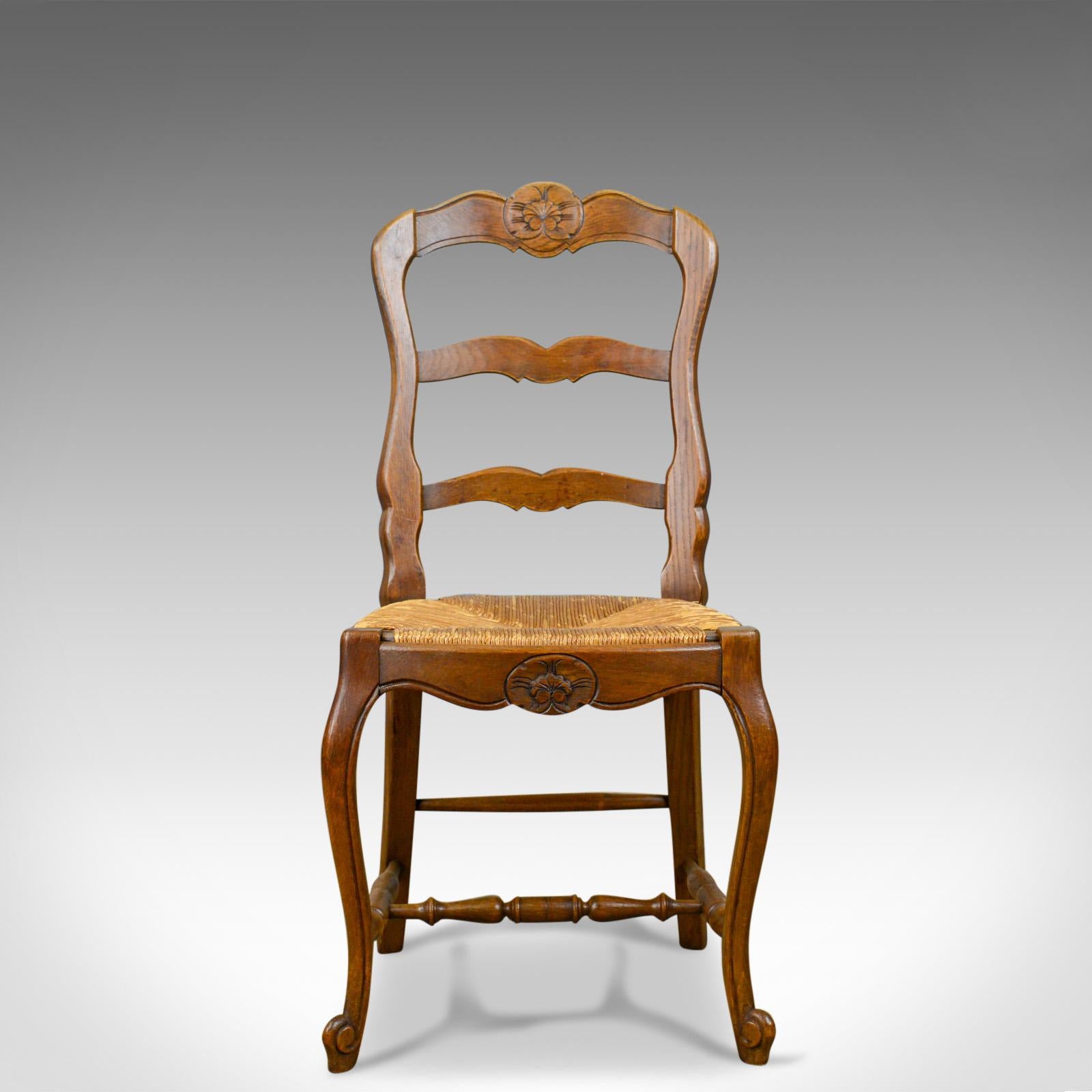 This is a set of six antique kitchen chairs in oak. French country dining chairs dating to the early 20th century, circa 1910.

Well crafted French country chairs with charm and character
Attractive tones to the French oak displaying grain