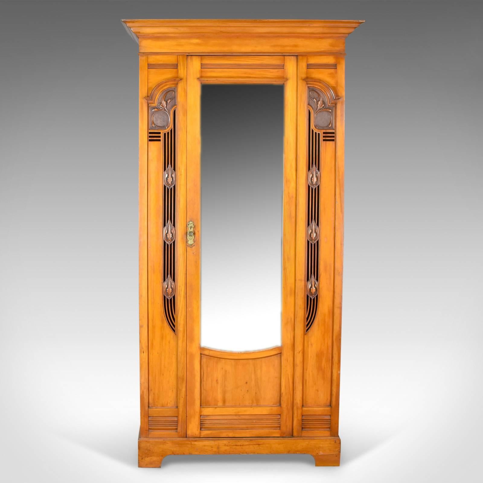 This is an antique single wardrobe in satinwood, an English compactum from the Art Nouveau movement of the early 20th century, circa 1920.

Delightful piece with Classic Art Nouveau overtones
Good color throughout with a desirable aged