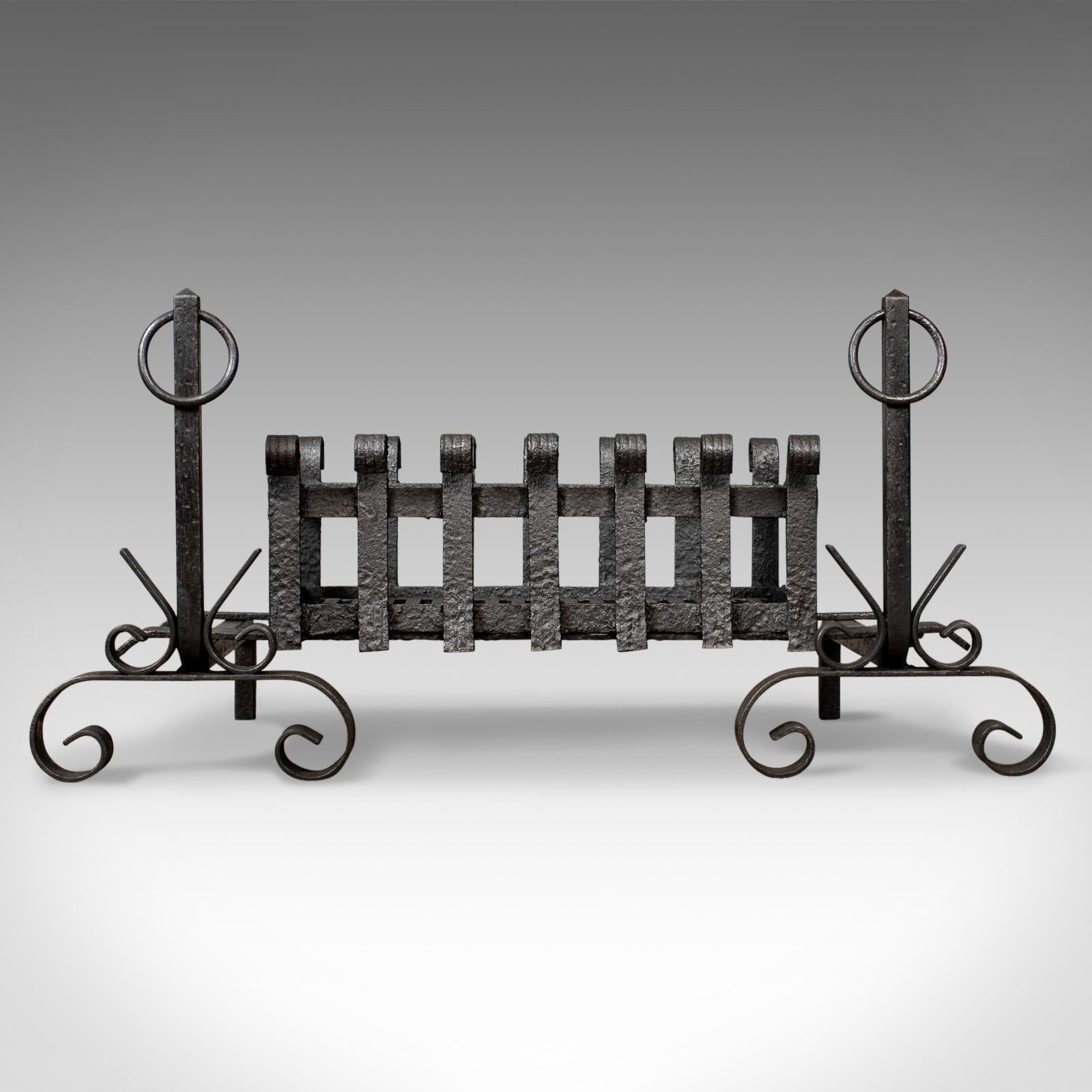 This is an antique fire basket and andirons, or fire dogs, an English, Victorian fireplace accessory with a removable iron grate dating to the early 20th century, circa 1900.

A fire basket raised on andirons presented in very good condition
A
