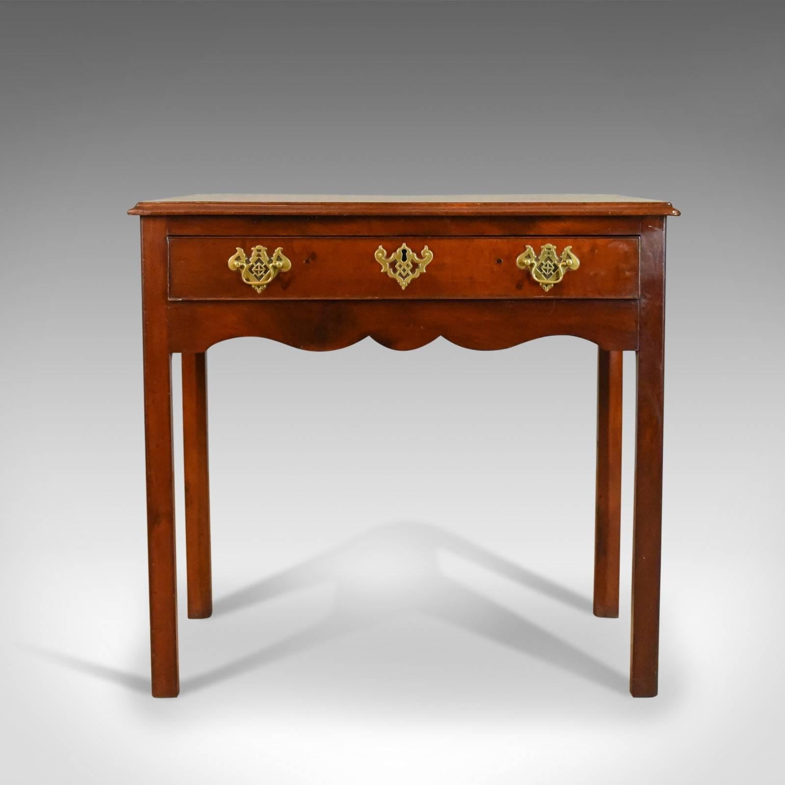 This is an antique lowboy in mahogany, a late Georgian, English side table dating to circa 1800.

Deep, rich color and finish to the quality mahogany
Attractive grain interest and a desirable aged patina
Clean back with skirting overhang for