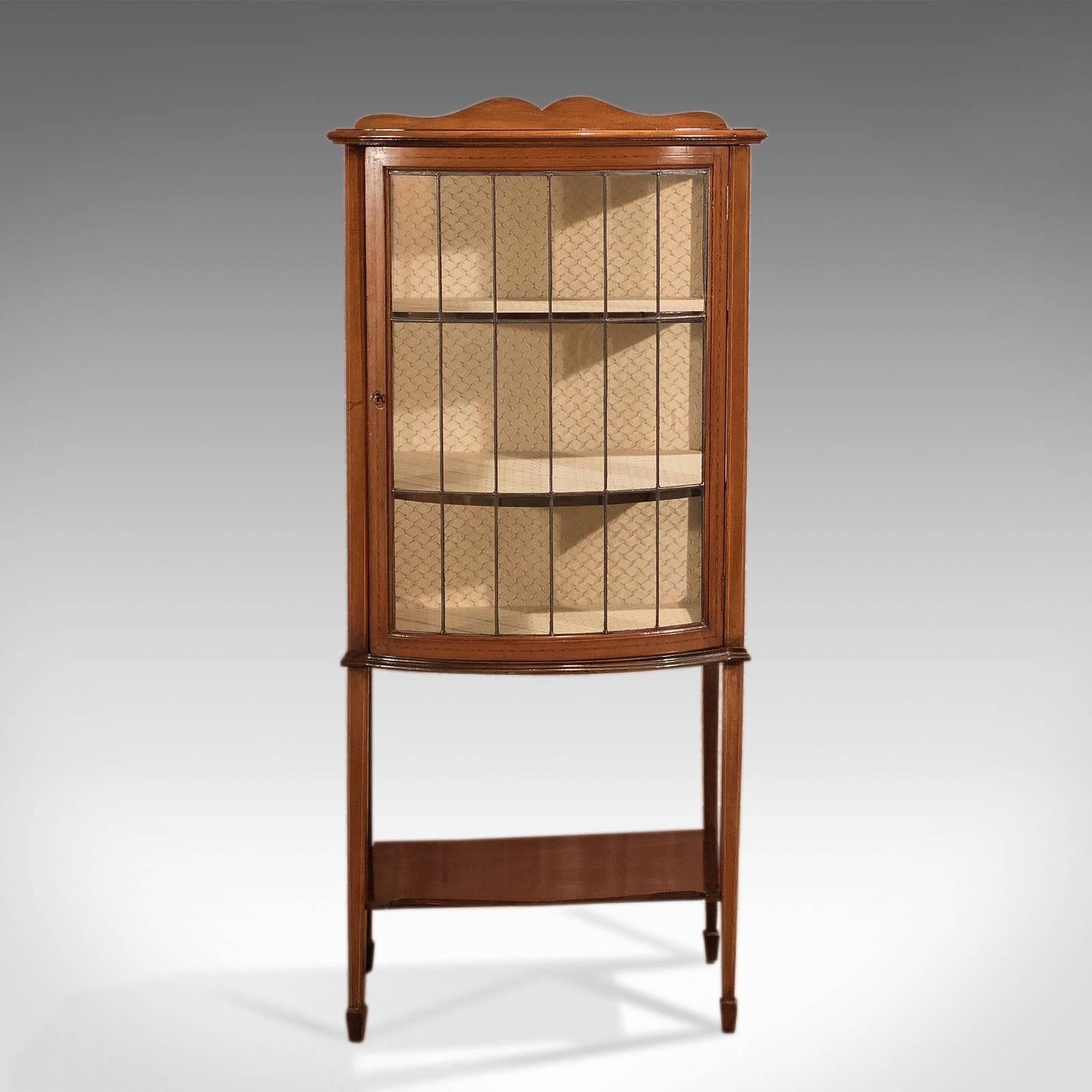 This is a superior quality, antique glazed display cabinet dating to the Edwardian period, circa 1910.

Attractive honey tones to the first class mahogany.
Desirable color and grain interest.
Inlaid with boxwood stringing to legs and