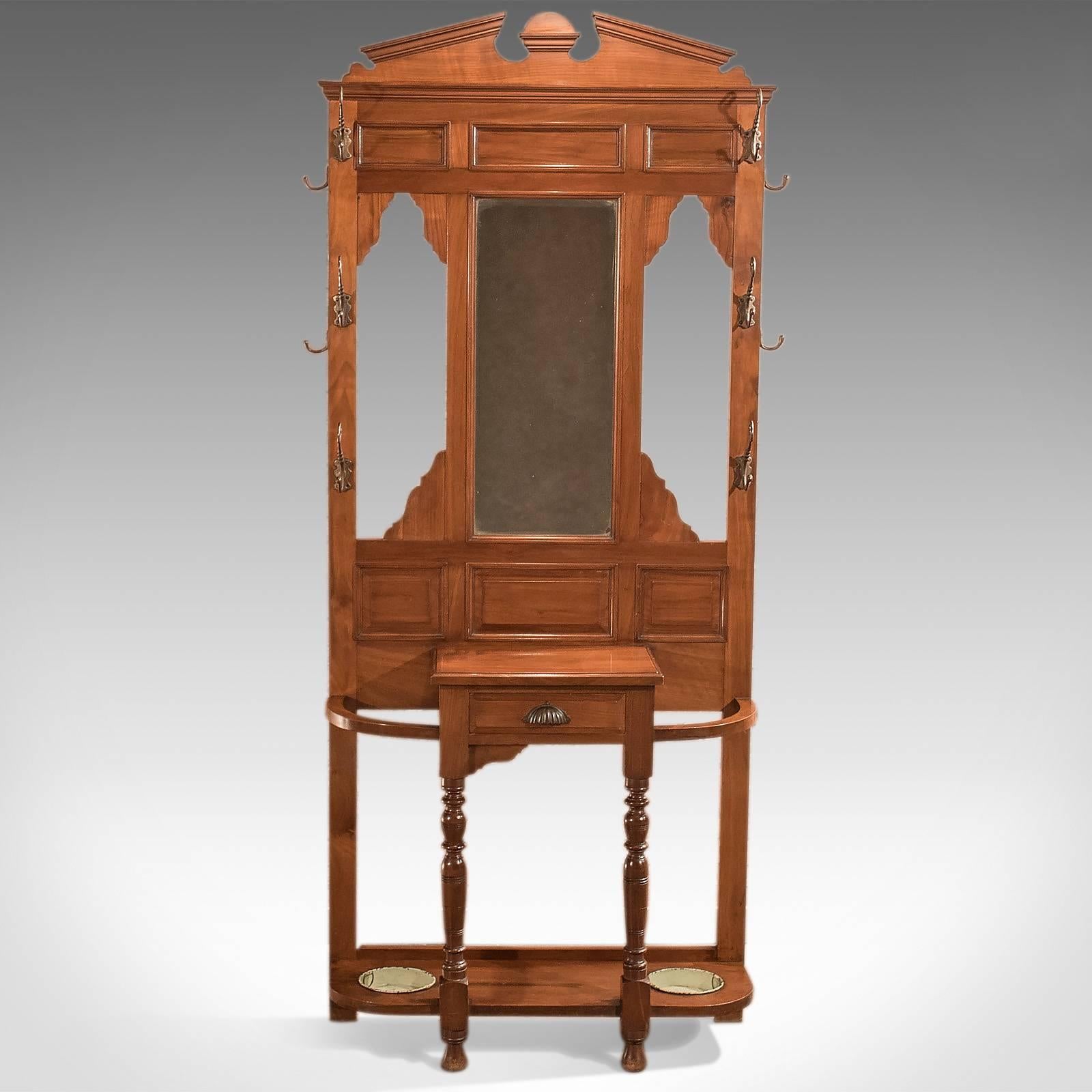 A handsome antique hall stand dating to the Edwardian period at the start of the 20th century, circa 1910.

Walnut with russet tones in a polished finish
Attractive grain detail

Raised on turned front legs
Central drawer dressed with shell