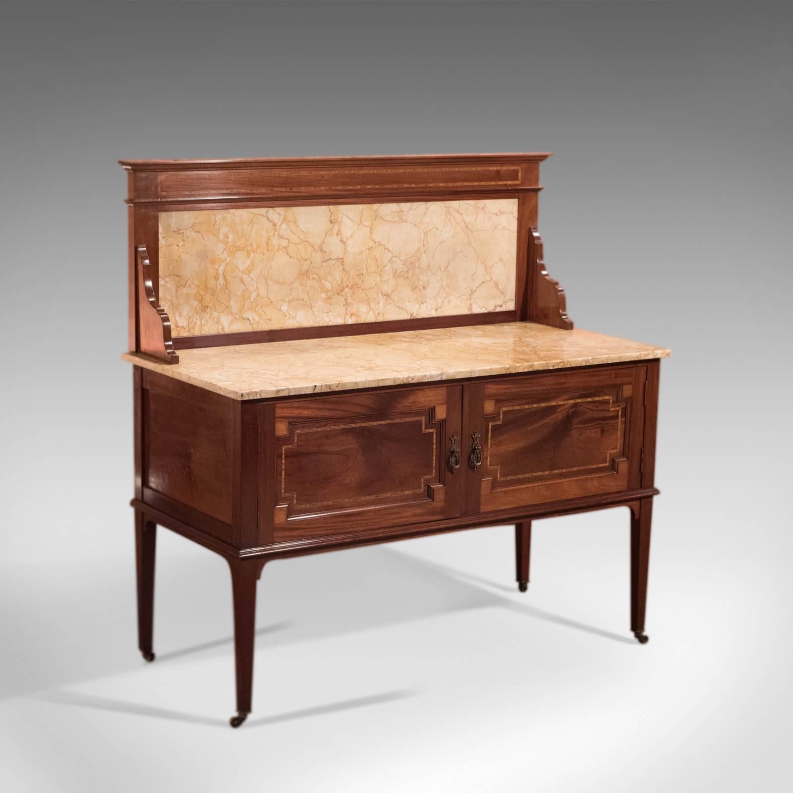 This is an antique, Edwardian, marble top wash stand in mahogany dating to circa 1910.

In fine proportion, of superior quality and rare to find one this size, this washstand is delightful as is or could be easily adapted for the modern bathroom
