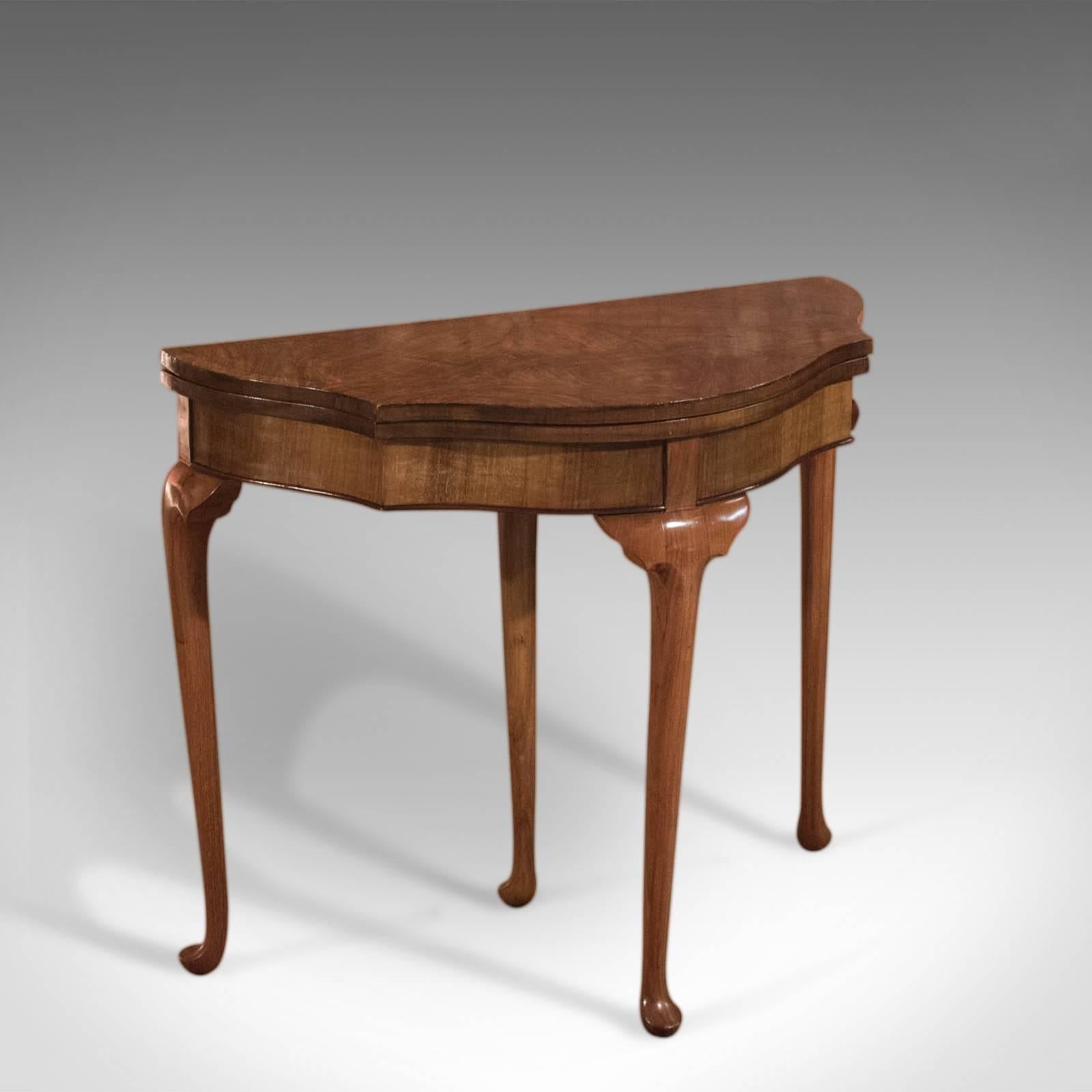 This is an antique, Edwardian, fold-over card table dating to circa 1910.

Raised on slender, tapering cabriole legs terminating in pad feet, the upper shaped brackets support the serpentine frieze detailed with lower edge moulding in contrasting