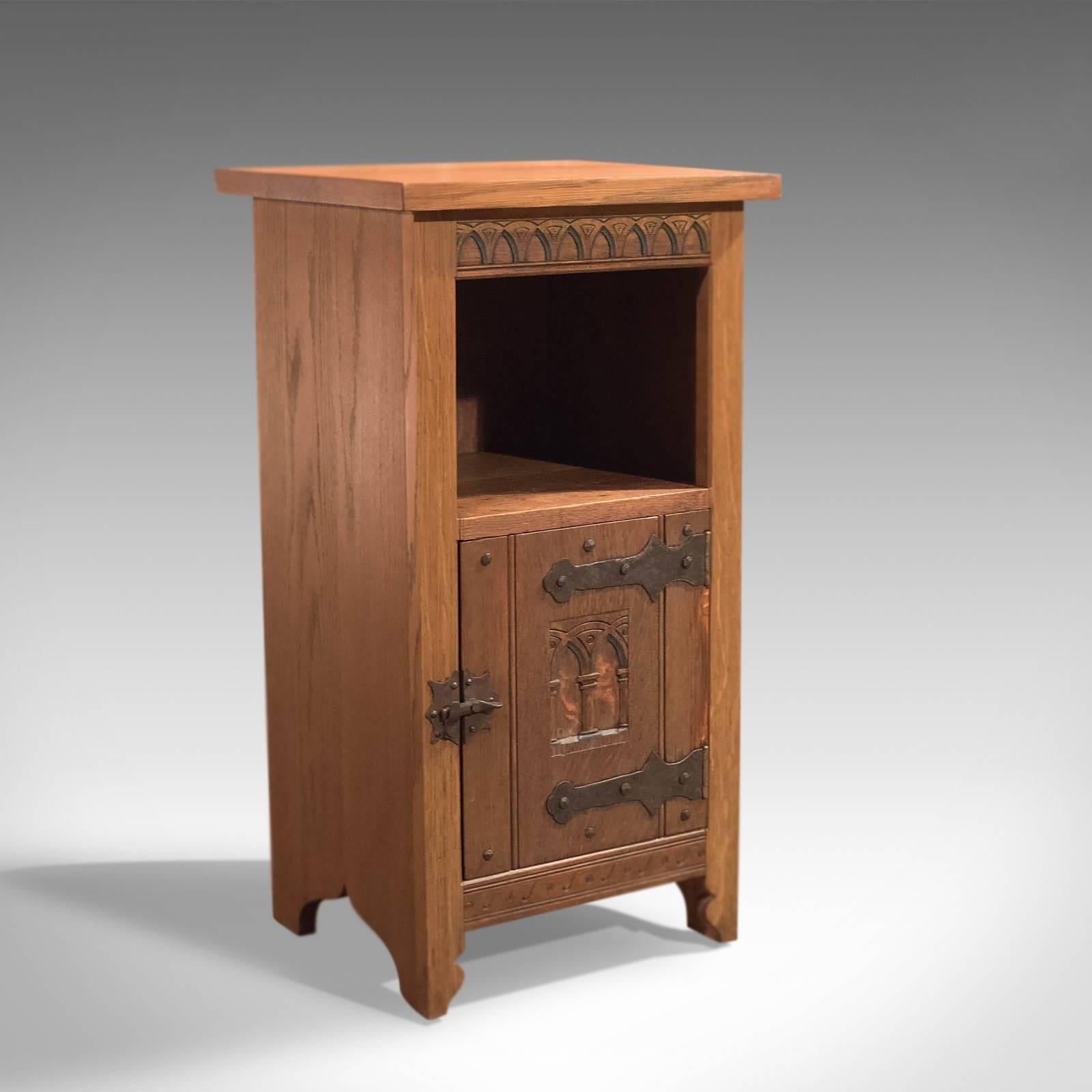 This is a vintage Mid-Century high quality oak bedside cabinet in the tradition of the Arts & Crafts movement.

Raised on shaped feet and in good proportion, the cabinet features a single cupboard below cubby hole.

The cabinet door is