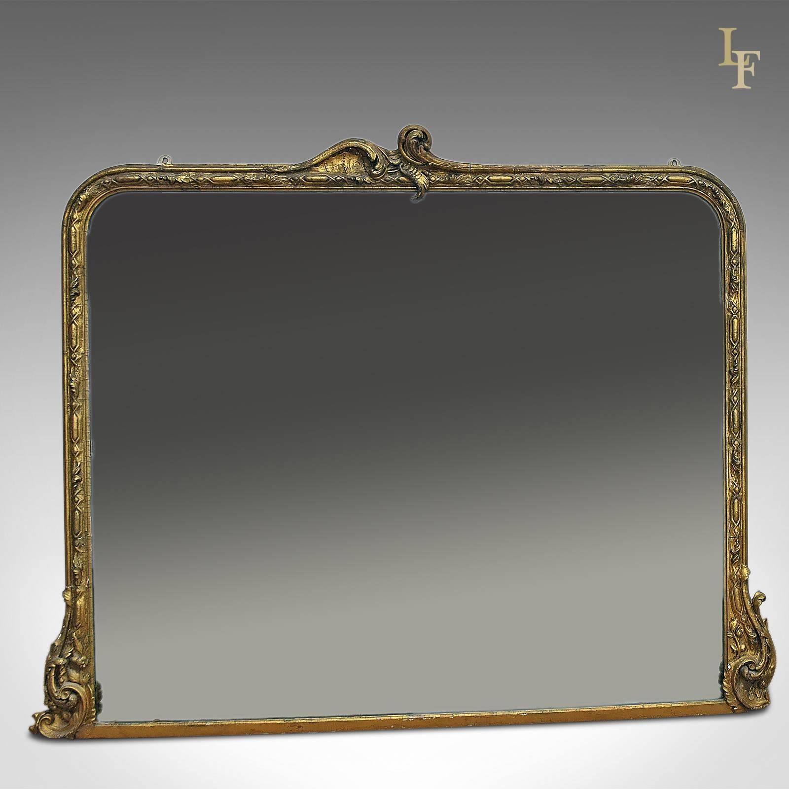 This is an antique overmantel mirror dating to the mid-Victorian period, circa 1860.
Victorian overmantel mirror in a Rococo style

Giltwood and gesso
Large original mirror plate
Ornate moulding details
Original panel back
Mounting lugs ready