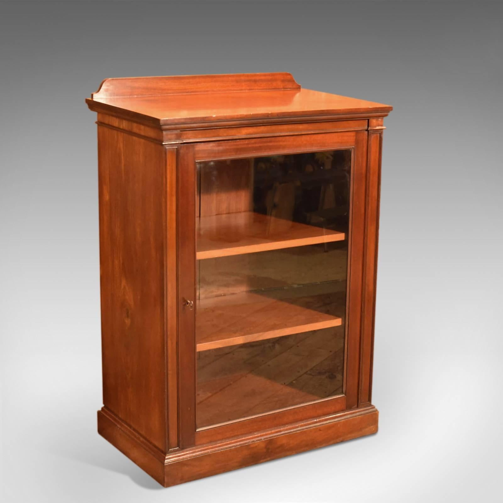 This is an antique, Victorian display cabinet with maritime proportion.

The mahogany in this generously sized pier cabinet displays with a deep, lustrous shine and a desirable aged patina.

Raised on a plinth base the deep, adjustable shelving