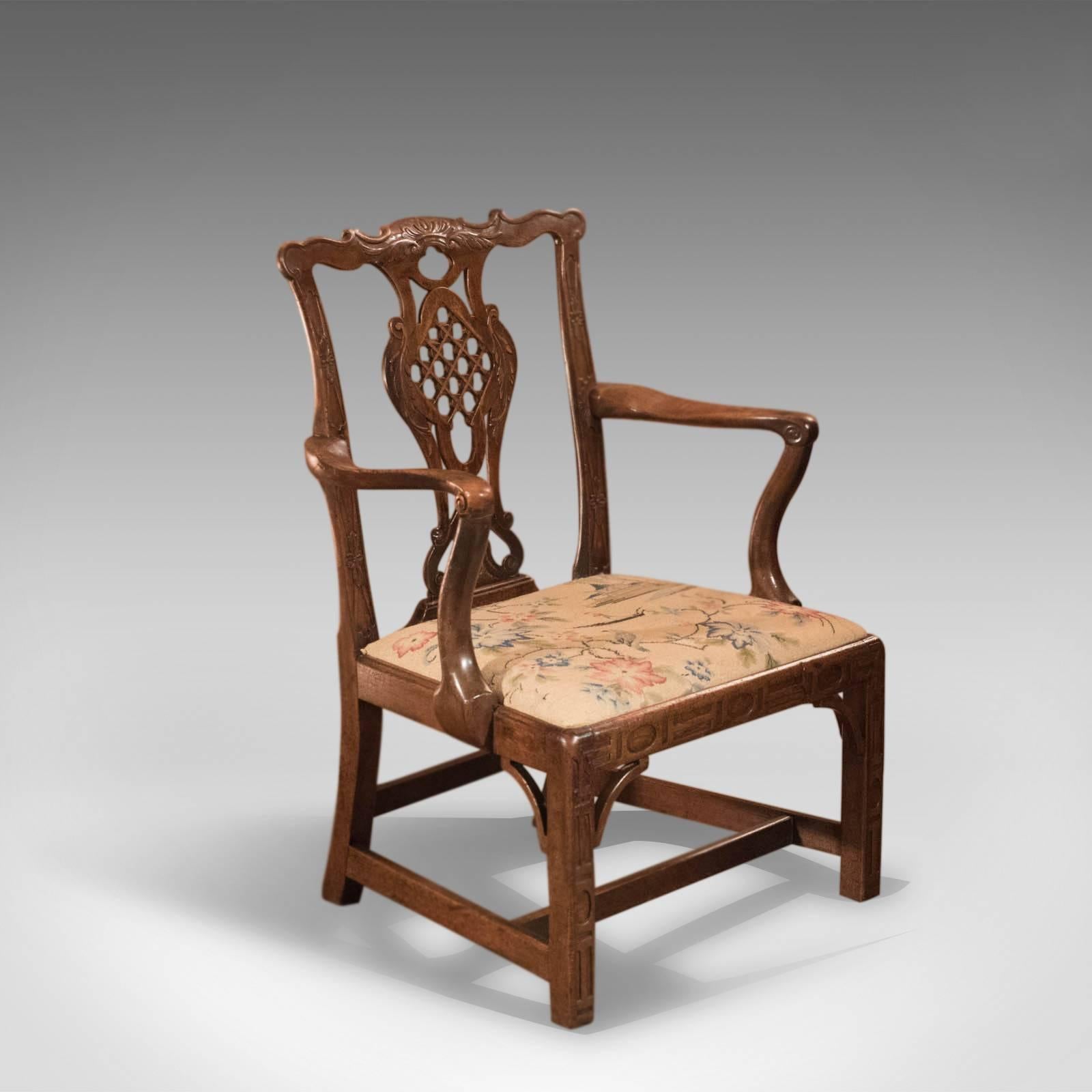 This is an antique, elbow chair with a Chinese lattice back splat, after the designs of Robert Mainwaring dating to the mid-18th century, circa 1760.

With all the hallmarks of Manwaring's designs this is a fine example from the period. Raised on