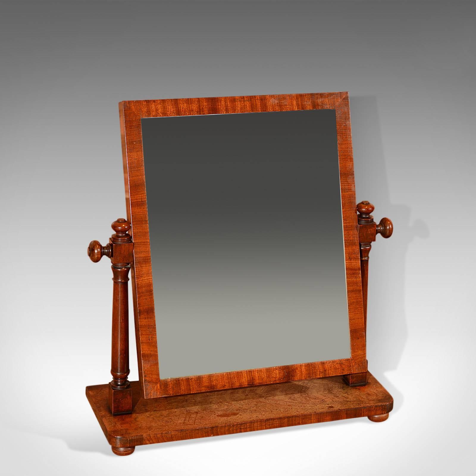 This is an antique, English, Regency platform toilet mirror dating to circa 1820.

Raised on flat bun feet the modest oblong platform, with rounded corners, displays desirable grain detail and patina and provides a stabile base for the beautifully