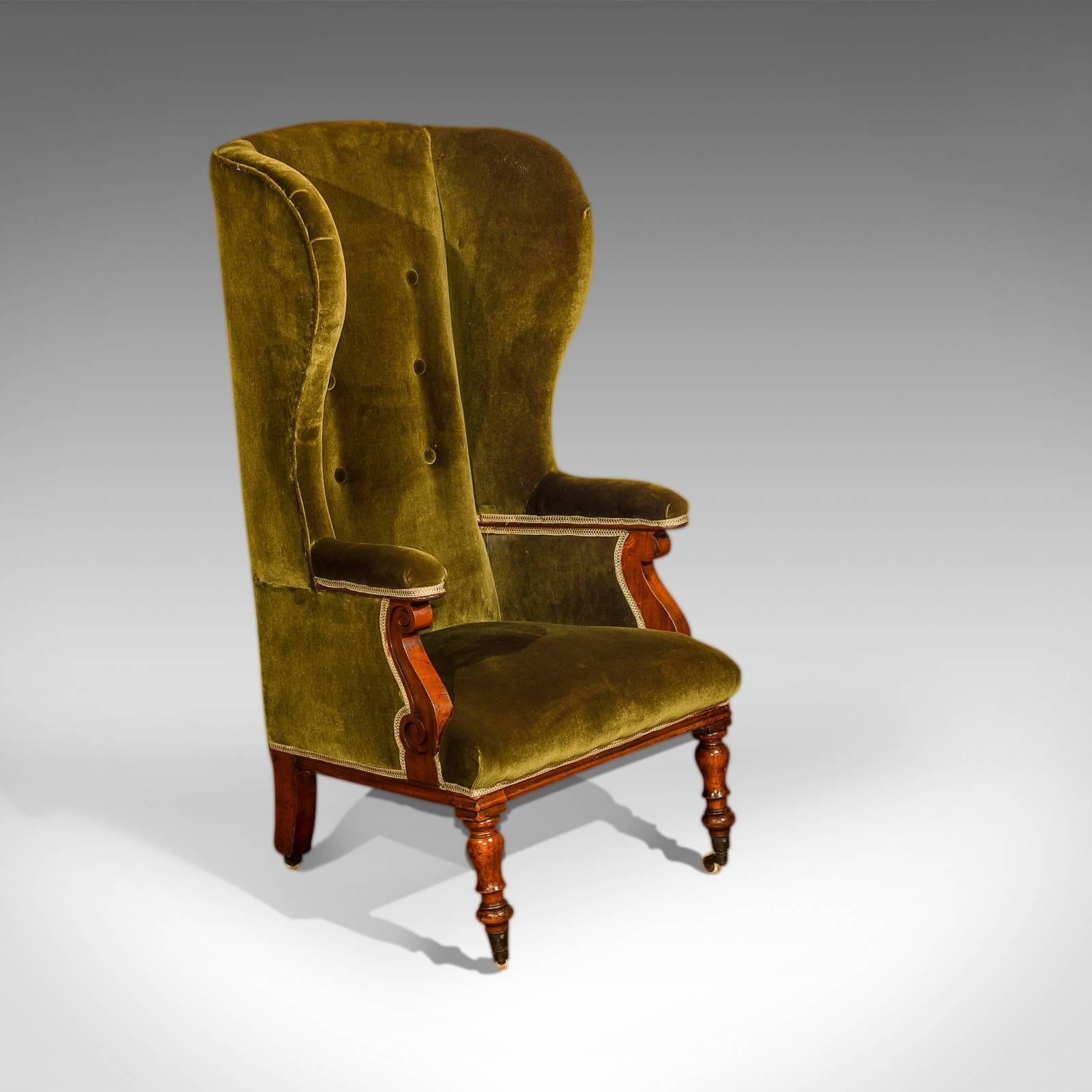 This is a superior quality Victorian antique wing back chair dating to c.1850.

At four feet tall, the high back on this winged chair would have been used to protect against draughts either fire side or as a porter's chair.

Raised on raked,