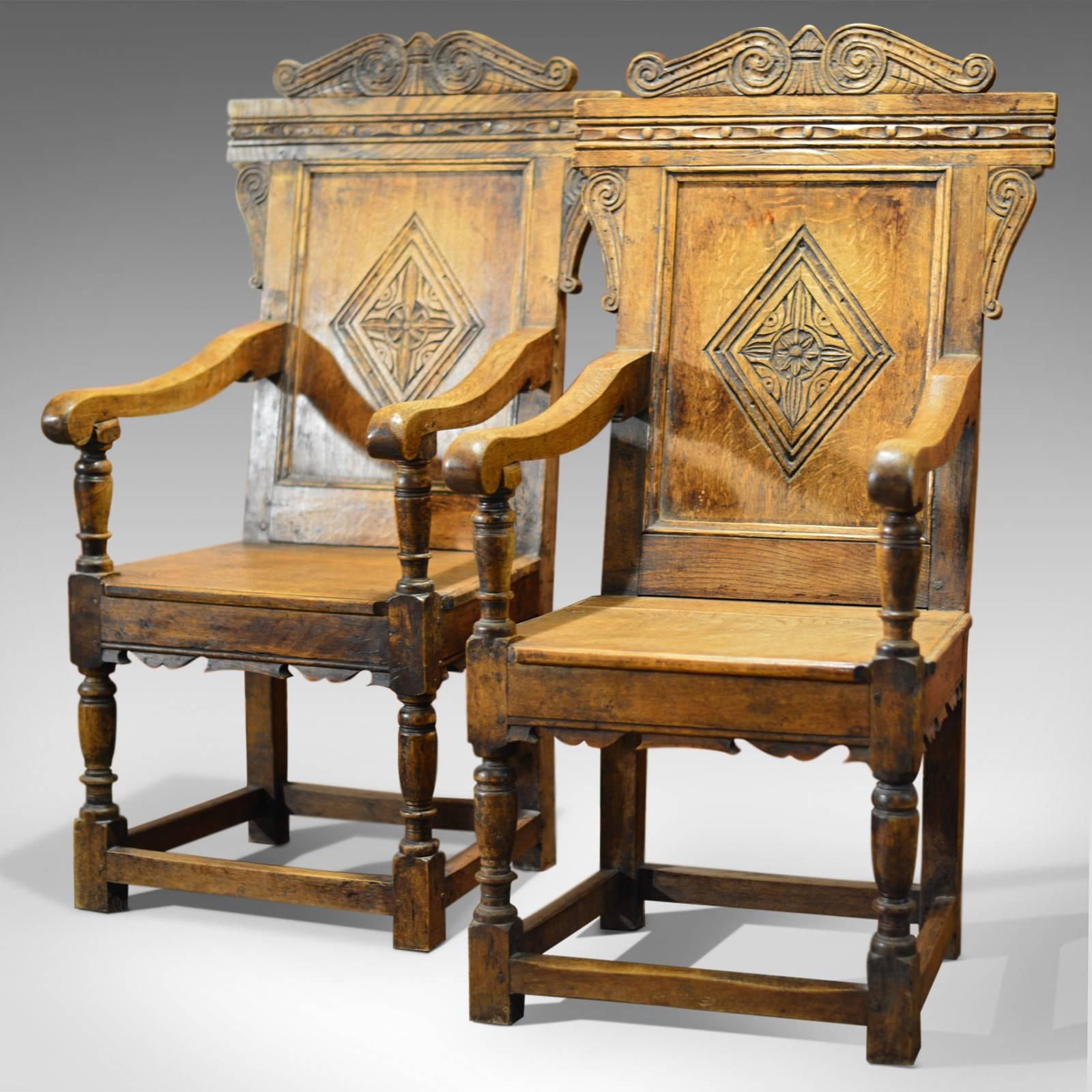 This is a 19th century, antique pair of baronial carver chairs.

This stunning pair of Victorian, 17th century revival armchairs are crafted in a wonderful honey colored English oak. The low level box stretcher unites the legs with generous stock