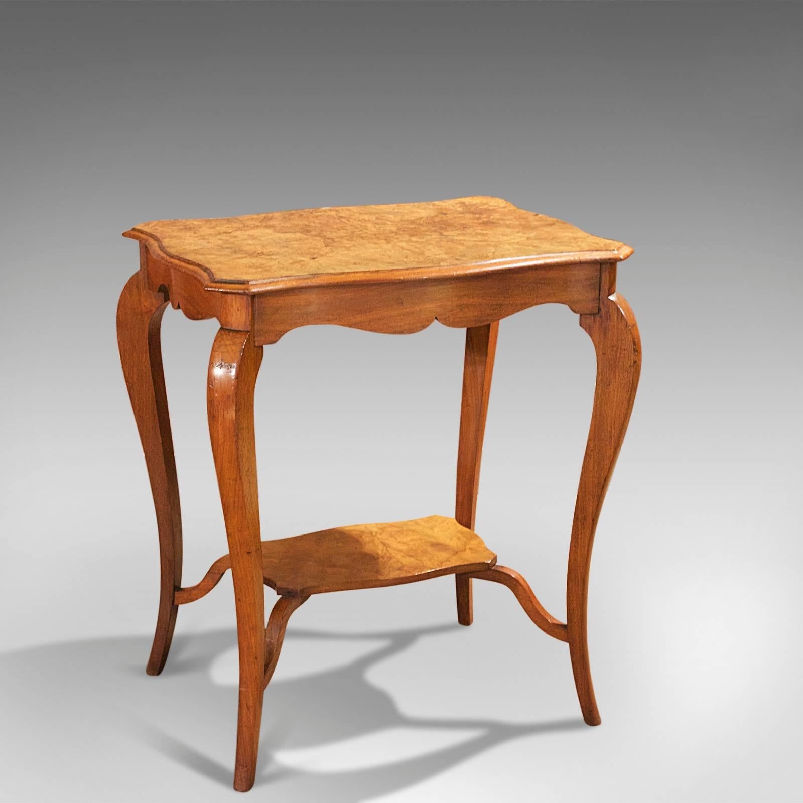 This is an antique side display table dating to circa 1900.

The top of this elegant table is quarter veneered in burr walnut with a moulded edge to the curved form with clipped corners.

The sinuous mahogany frame features tapered, cabriole legs
