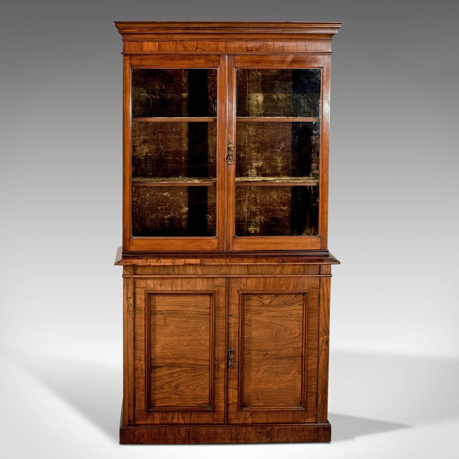 This is an antique display cabinet, a tall, Victorian, bookcase dating to circa 1900.

Stunning, well figured in a very desirable pallet
Desirable aged patina in a wax polished finish
Luxurious velvet lining to the upper cabinet display area

With
