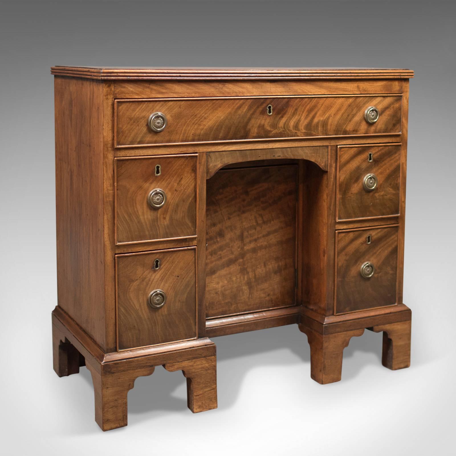 This is an antique kneehole desk, late 19th century, Victorian in the Georgian taste, circa 1870.

Crafted in quality flame mahogany with grain interest, good colour and an aged patina
Raised on Classic, Georgian inspired, bracket feet
Recessed