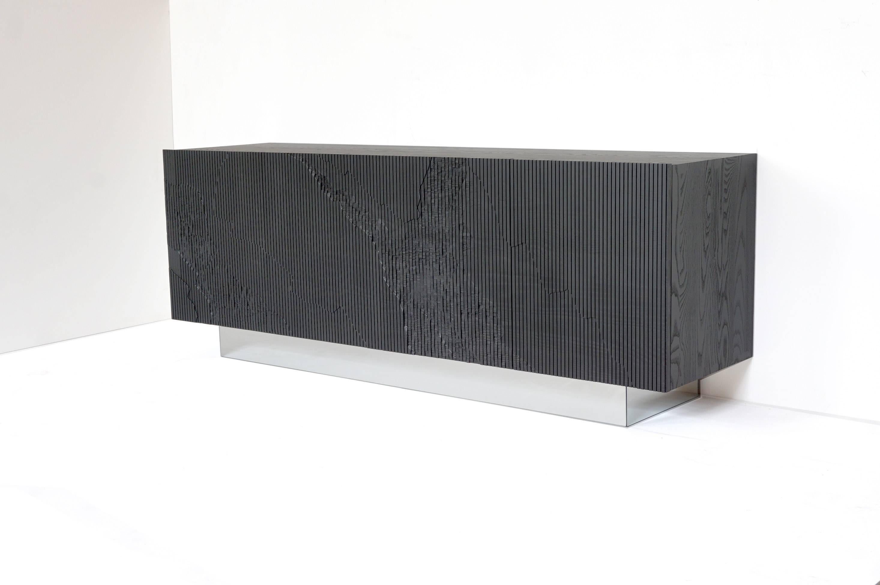 Both monumental and subtle, the Shale Credenza brings the intricacies of nature’s geology indoors. The wood doors are scored vertically across the grain, and details of a cliff’s facade, mapped out by Simon Johns, are carved into them replicating