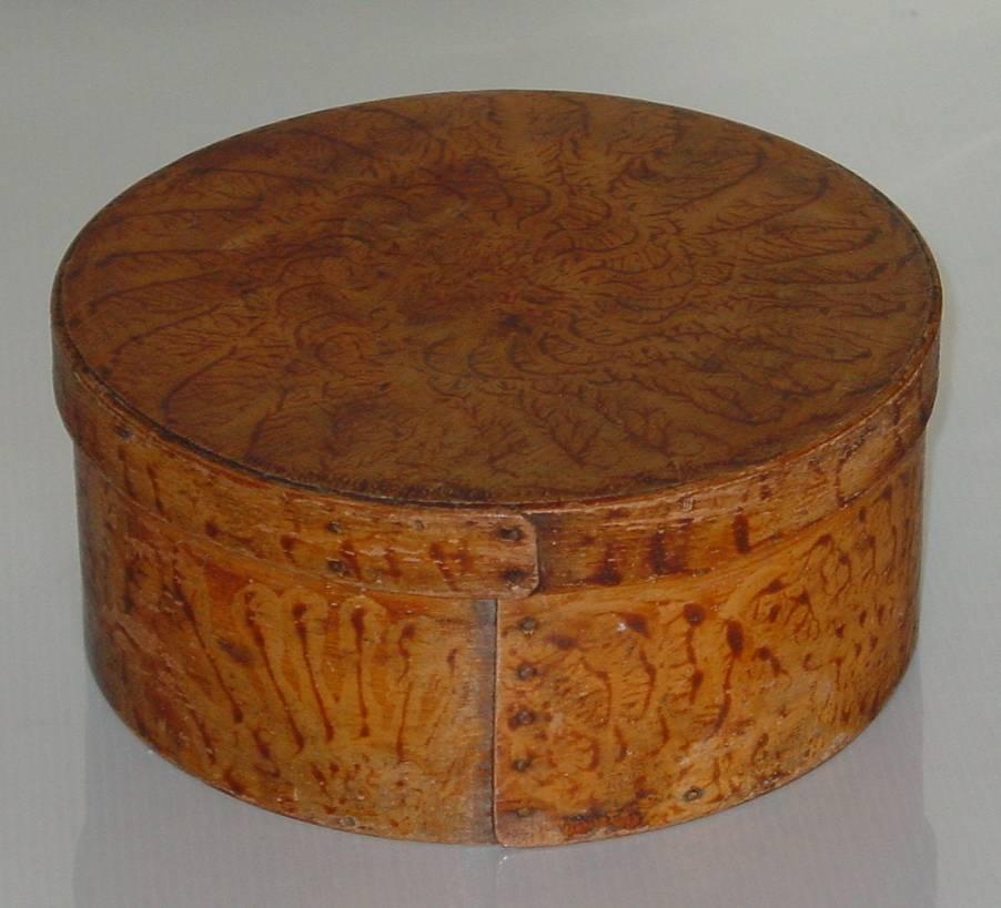 A maple and pine round covered storage box decorated all-over with superb original grain-painting. A wonderful example of a country storage box perfect for a variety of uses. 

Origin: New England
Date: circa 1840
Measures: Height 3 1/2