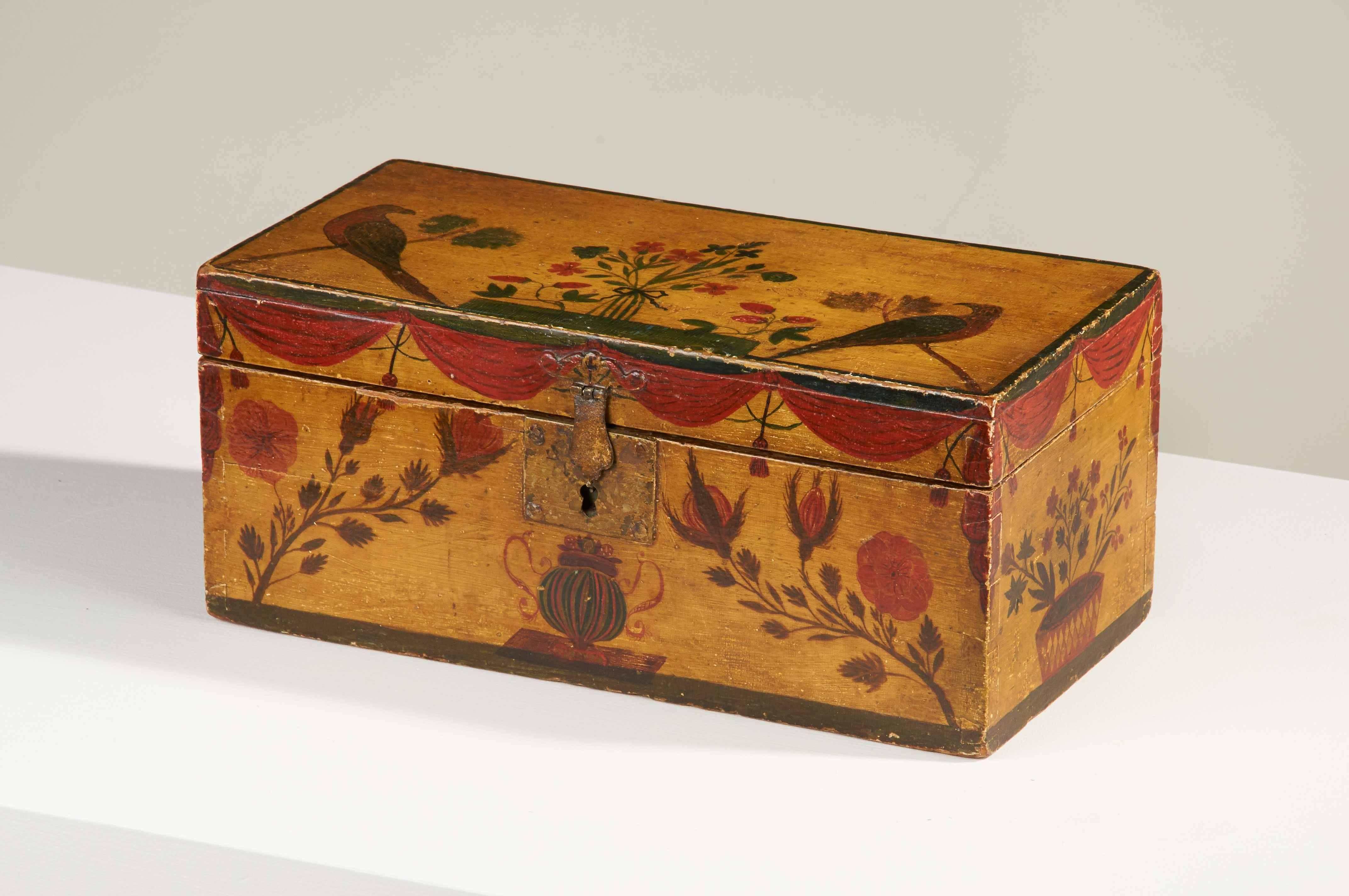 This exquisite box by an unknown maker, likely working in the Hallowell-Gardiner area of Maine, is covered with decoration, the birds delightfully flanking a spray of red and blue flowers tied with a ribbon, the front and sides with urns and