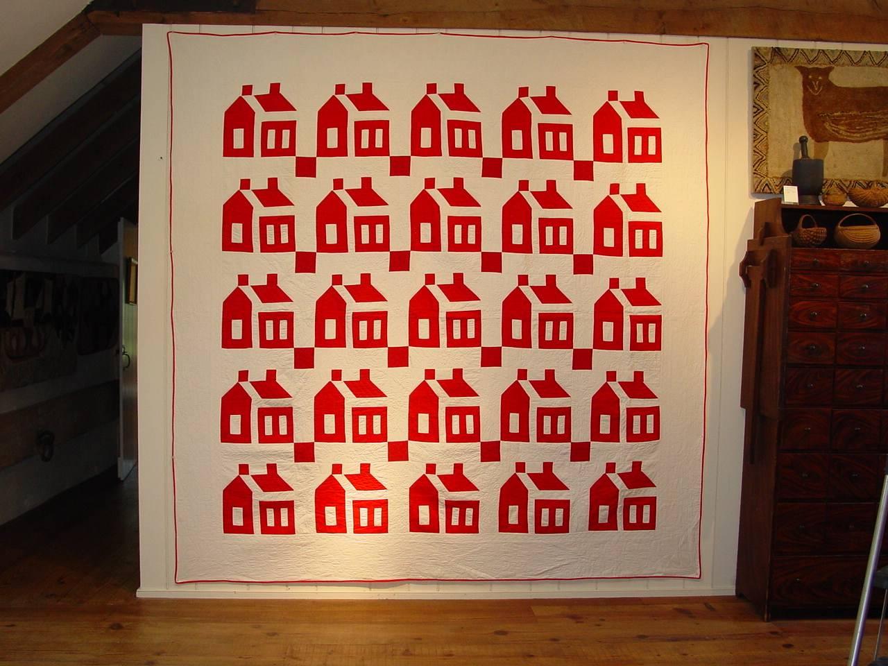 The wide spacing between the components of each of the 25 red houses against the white ground create an overall abstract quality to this cotton quilt with such exceptional floral and diamond quilting.  Likely made in New England and a wonderfully