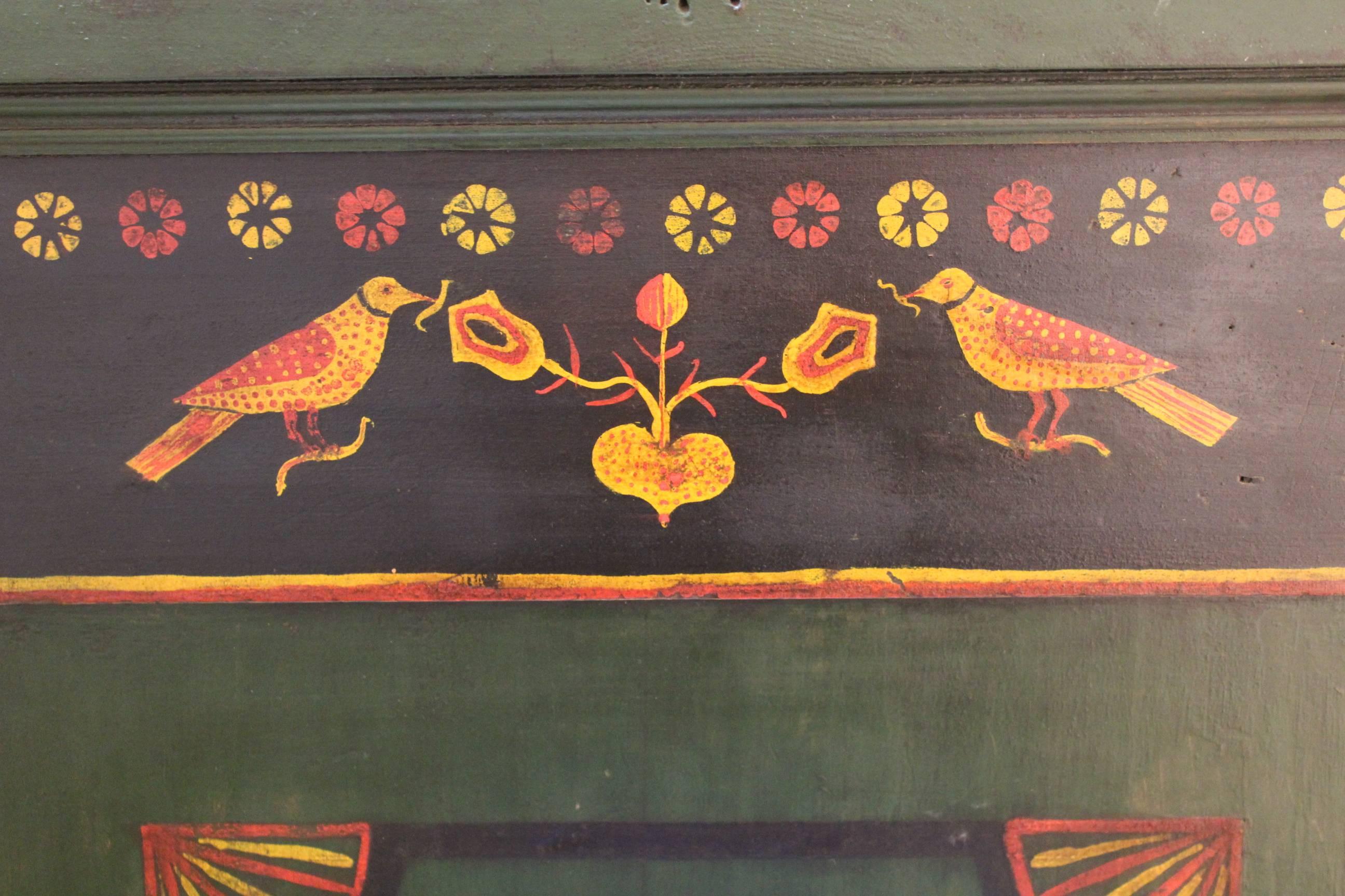 A poplar and pine four-drawer chest with original hand-painted green and blue ground and stencil decorations including birds and flowers. Dated 