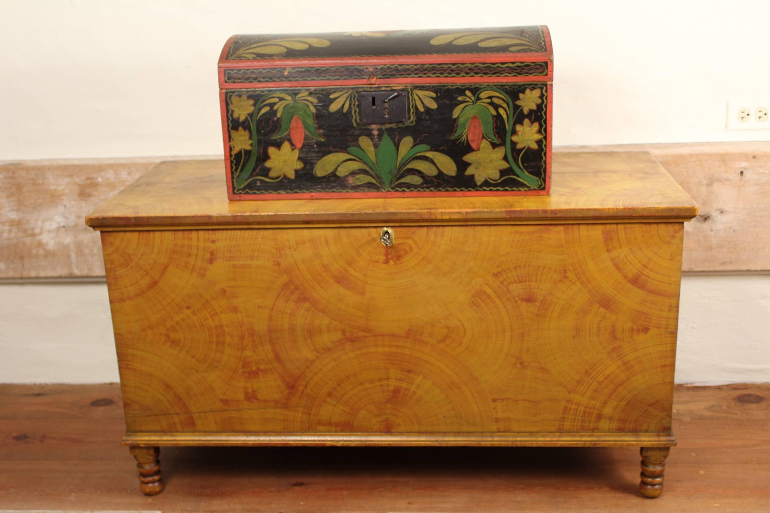 A Pennsylvania yellow-painted pine blanket chest featuring bold fan-shaped decoration over turned feet. Attributed to Jacob and Heinrich Blatt, Bern (now centre) Township, Berks County, Pennsylvania and signed and dated 1841 with further indistinct