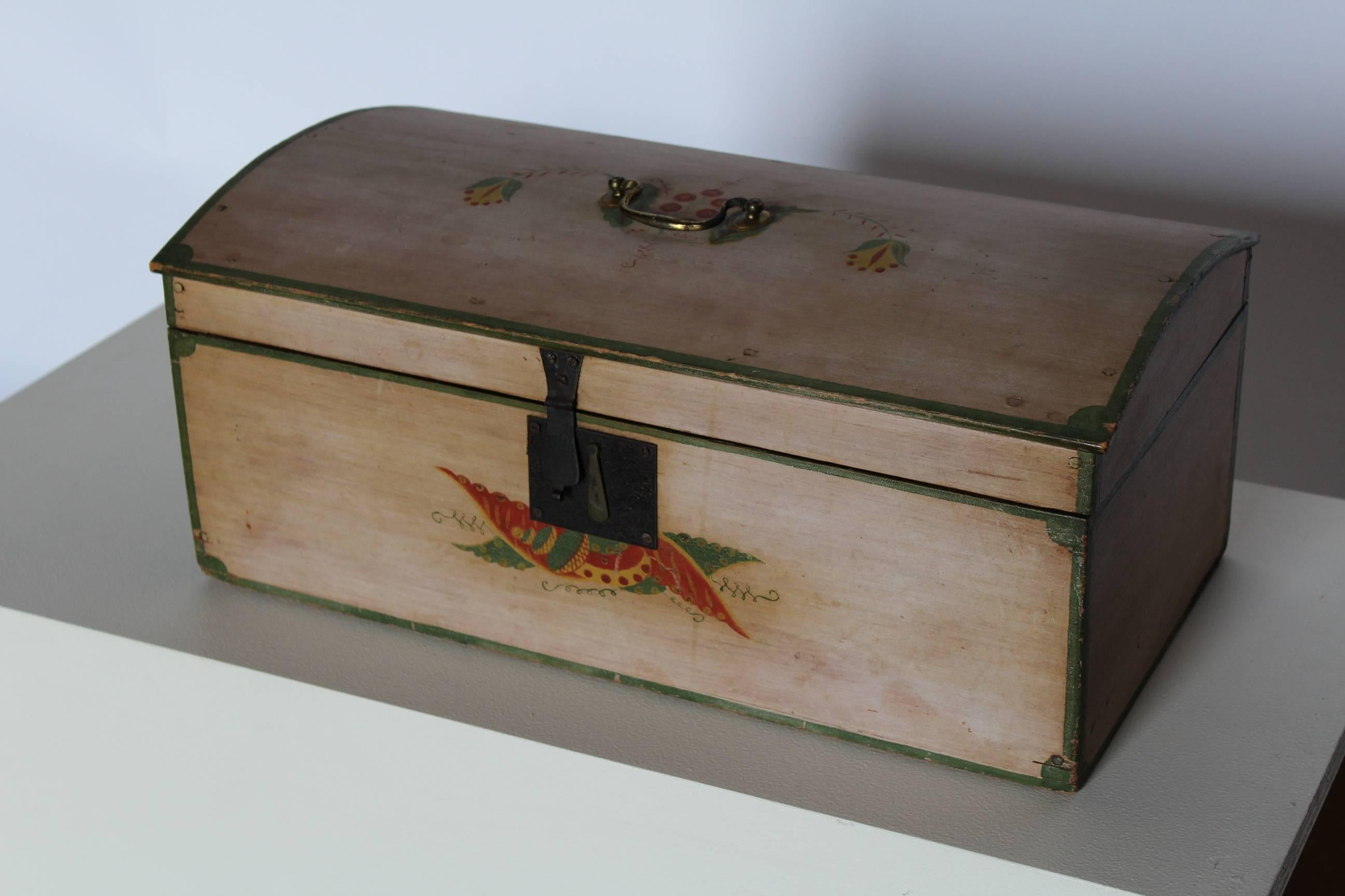 A dome-top box attributed to Daniel Stewart of Farmington, Maine, retaining the original fanciful decorated finish in red, green and yellow on a salmon ground. This charming dome-top box is a wonderful example of American Folk Art painted