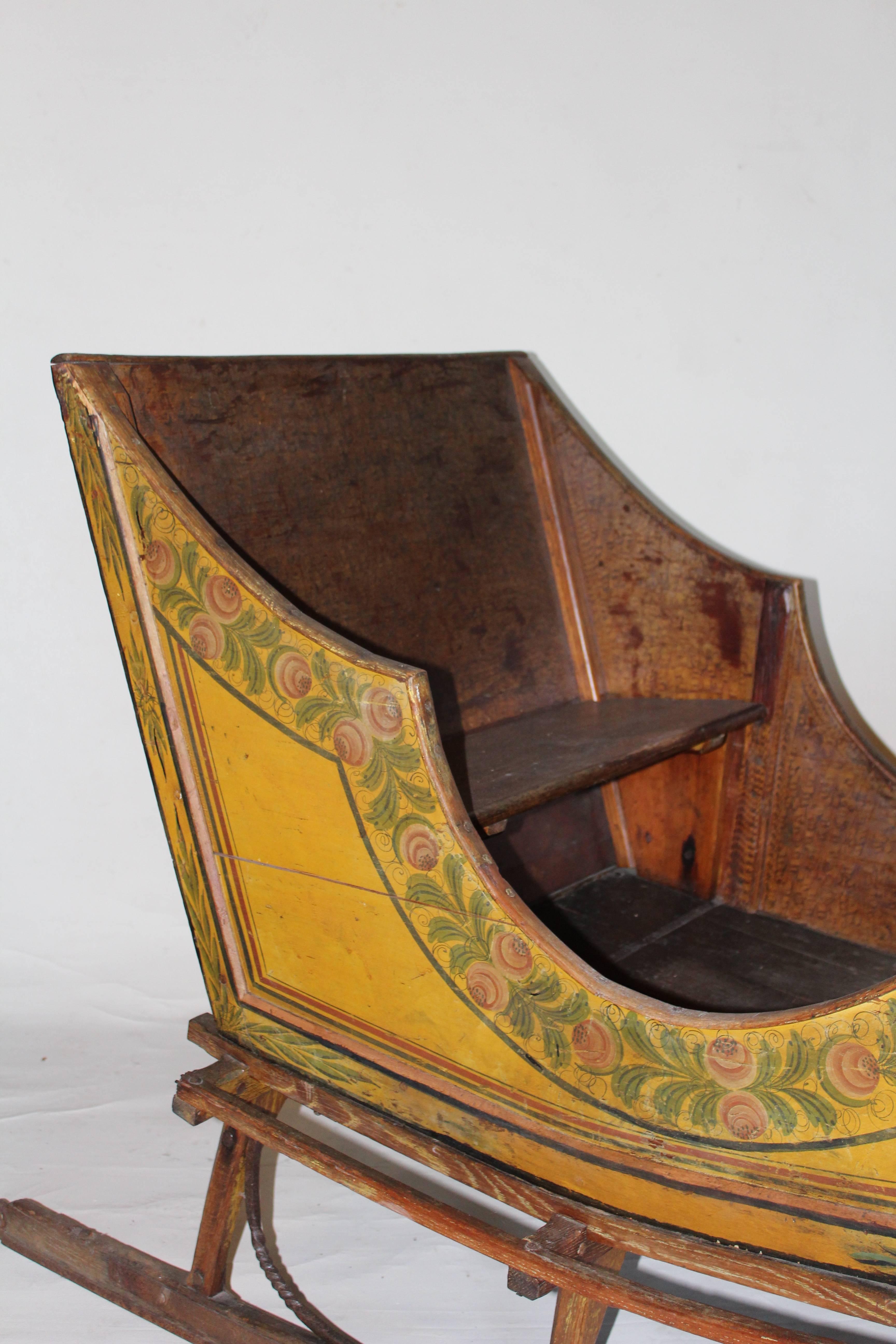 Wonderfully small in scale and retaining its original floral decorated surface, this unique horse-drawn sleigh is the kind of interesting item we have always loved finding. The sleigh is decorated in repeating rose and leaf motifs with an outer