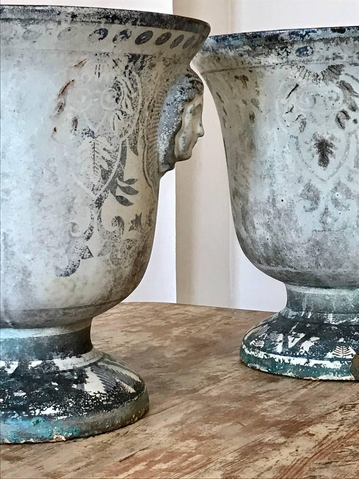 Two mid-19th century enameled cast iron urns; classical decoration in the enamel; 